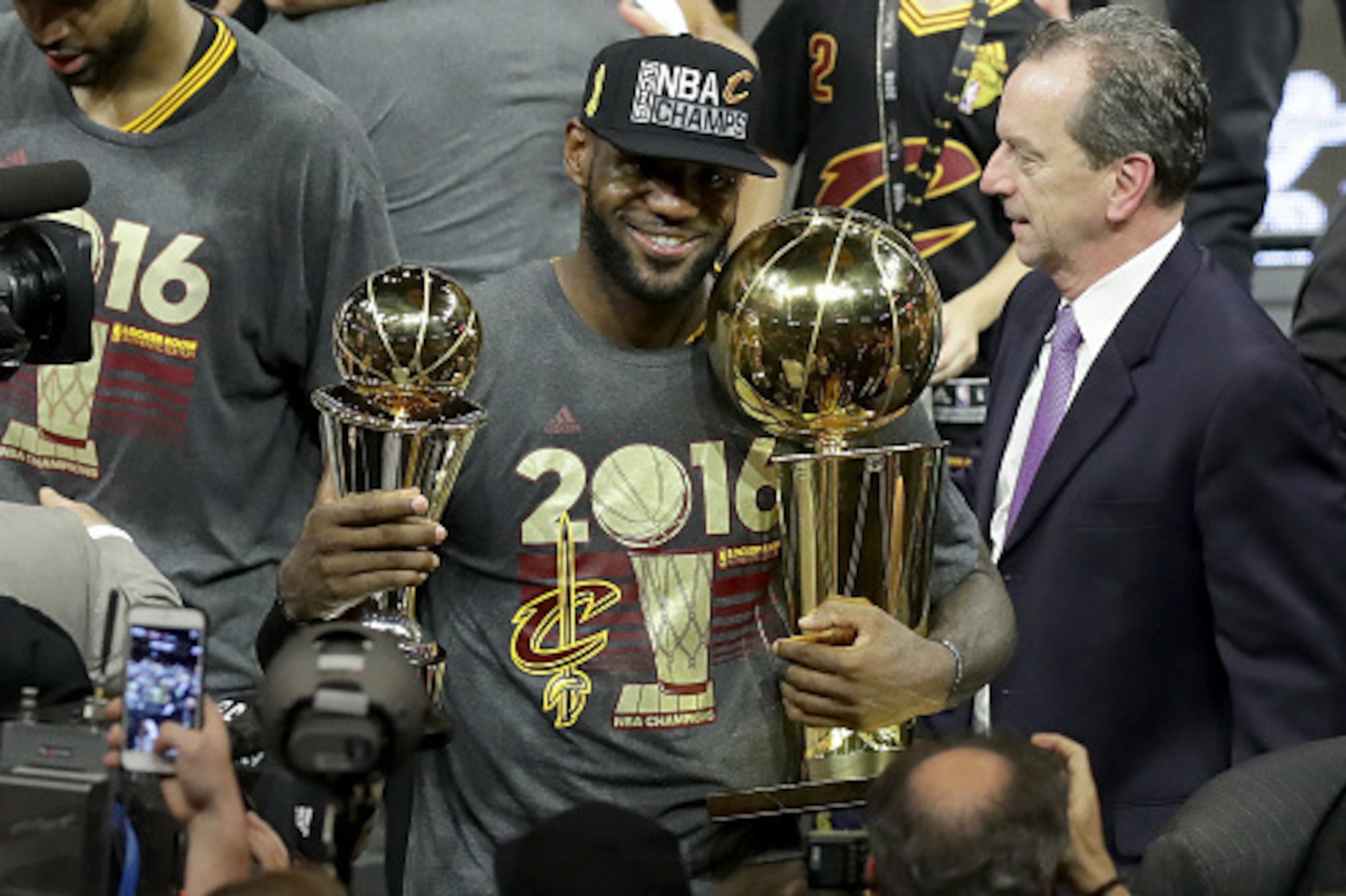 OAKLAND, CA - JUNE 19:  LeBron James #23 of the Cleveland Cavaliers holds the Larry O'Brien Championship Trophy and the Bill Russell NBA Finals Most Valuable Player Award after defeating the Golden State Warriors 93-89 in Game 7 of the 2016 NBA Finals at 