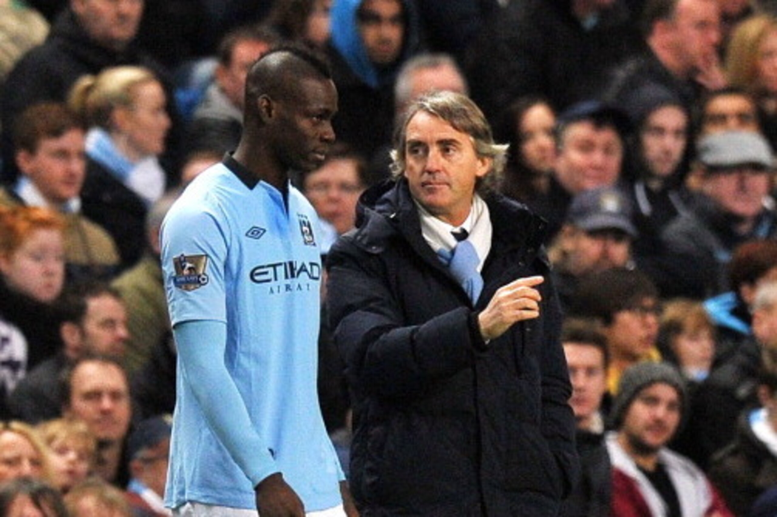 Manchester City's Mario Balotelli stands next to manager Roberto Mancini when coming on as a substitute during the English FA Cup third round football match between Manchester City and Watford at The Etihad stadium in Manchester, north-west England on Jan