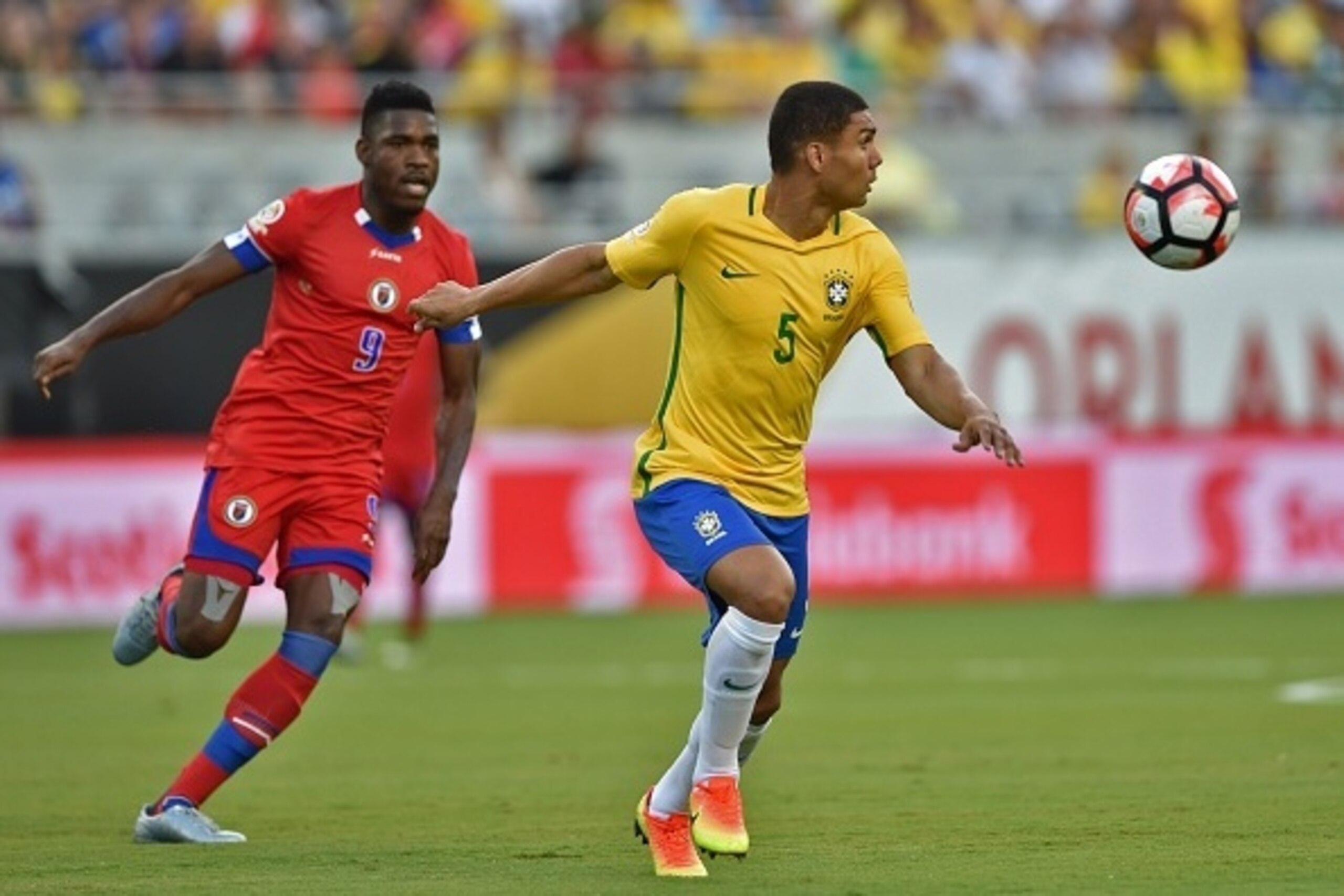 Brazil's Casemiro (R) vies for the ball with Haiti's Kervens Belfort during a Copa America Centenario football match in Orlando, Florida, United States, on June 8, 2016.  / AFP / Hector RETAMAL        (Photo credit should read HECTOR RETAMAL/AFP/Getty Ima