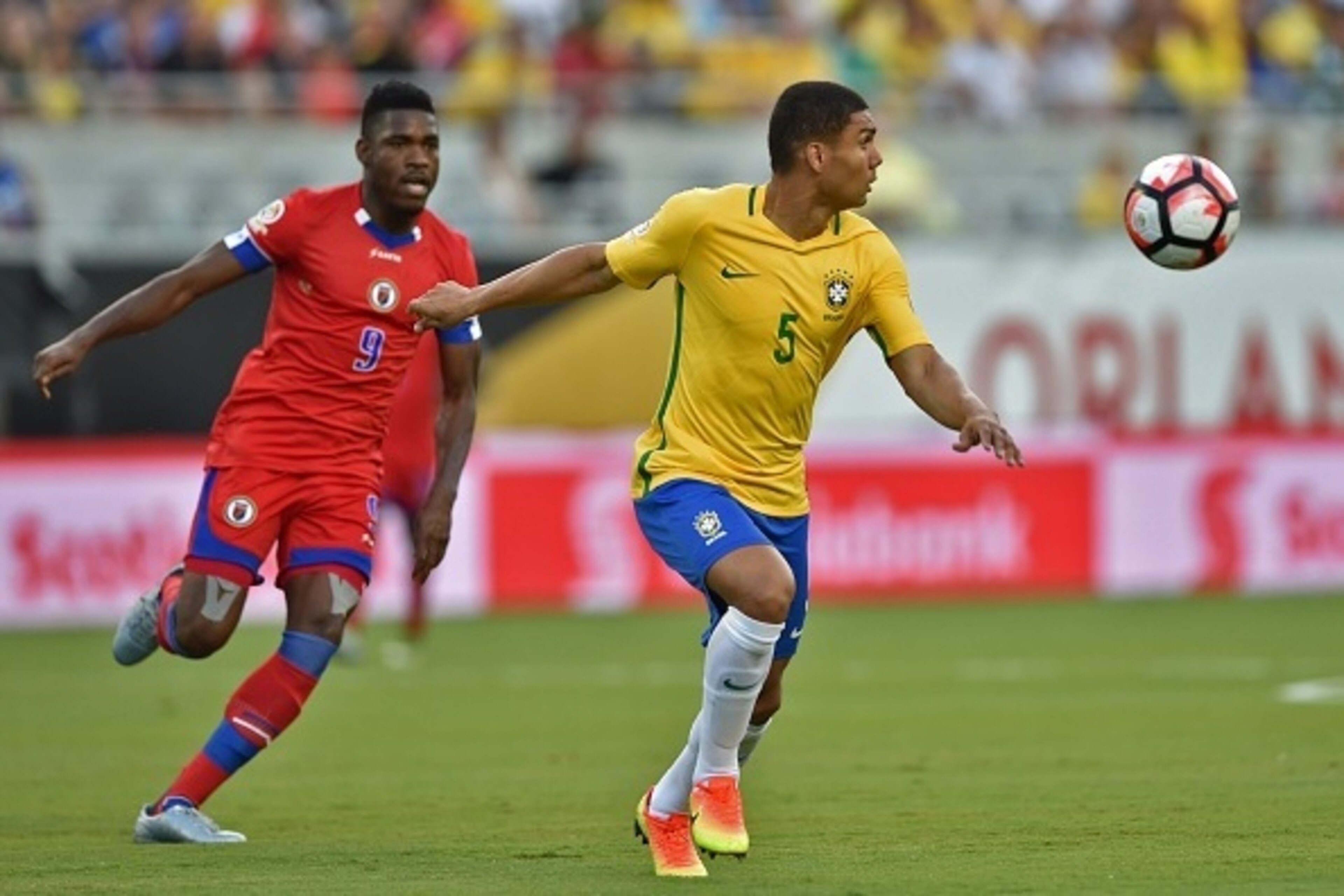 Brazil's Casemiro (R) vies for the ball with Haiti's Kervens Belfort during a Copa America Centenario football match in Orlando, Florida, United States, on June 8, 2016.  / AFP / Hector RETAMAL        (Photo credit should read HECTOR RETAMAL/AFP/Getty Ima