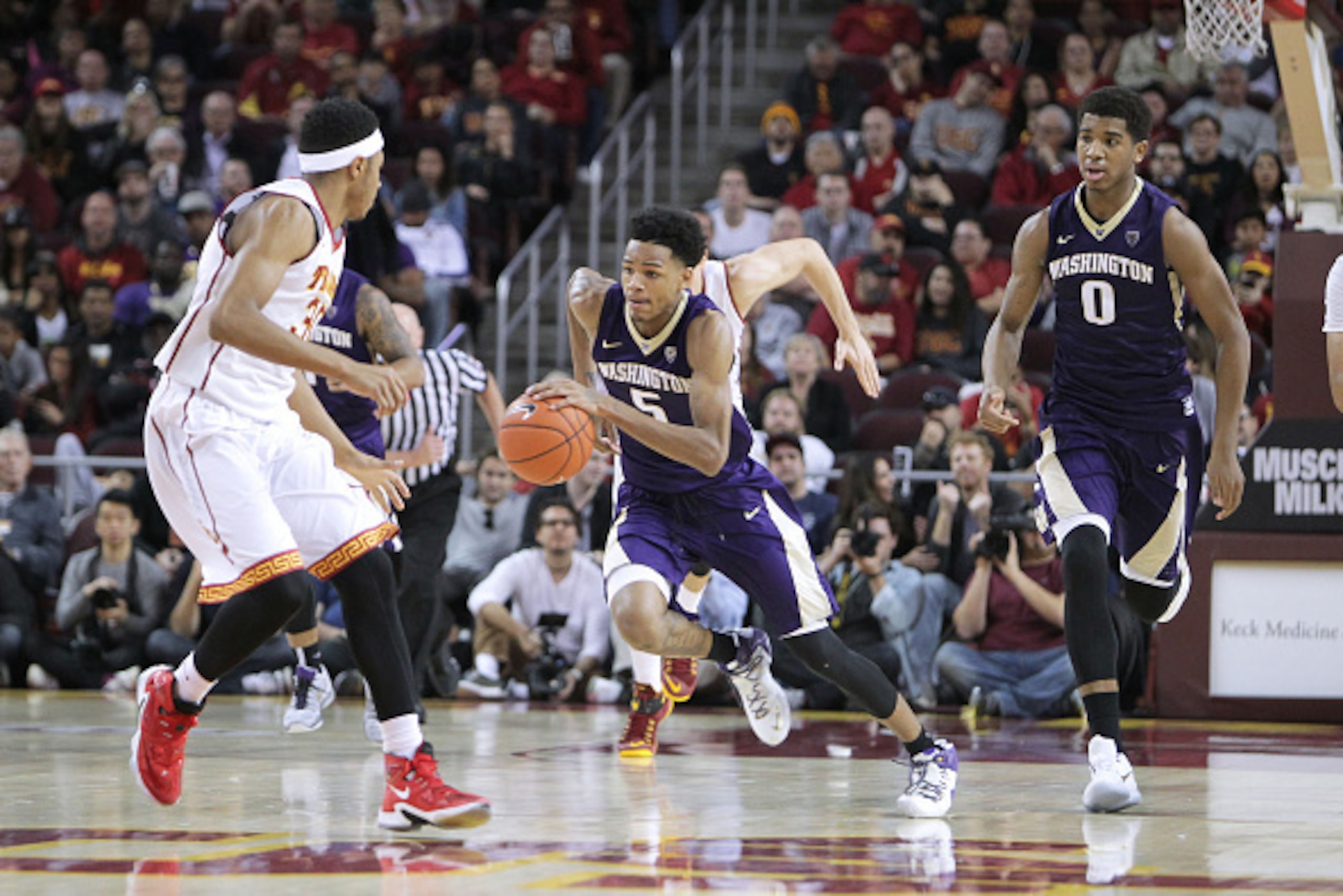 LOS ANGELES, CA - JANUARY 30: Dejounte Murray #5 of the Washington Huskies pushes the ball up the court against Elijah Stewart #30 of the USC Trojans during a NCAA college basketball game at Galen Center on January 30, 2016 in Los Angeles, California. (Ph LOS ANGELES, CA - JANUARY 30: Dejounte Murray #5 of the Washington Huskies pushes the ball up the court against Elijah Stewart #30 of the USC Trojans during a NCAA college basketball game at Galen Center on January 30, 2016 in Los Angeles, California. (Ph