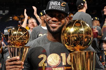 OAKLAND, CA - JUNE 19:  LeBron James #23 of the Cleveland Cavaliers celebrates with the Larry O'Brien NBA Championship Trophy and the Bill Russell NBA Finals Most Valuable Player Award after winning Game Seven of the 2016 NBA Finals against the Golden Sta