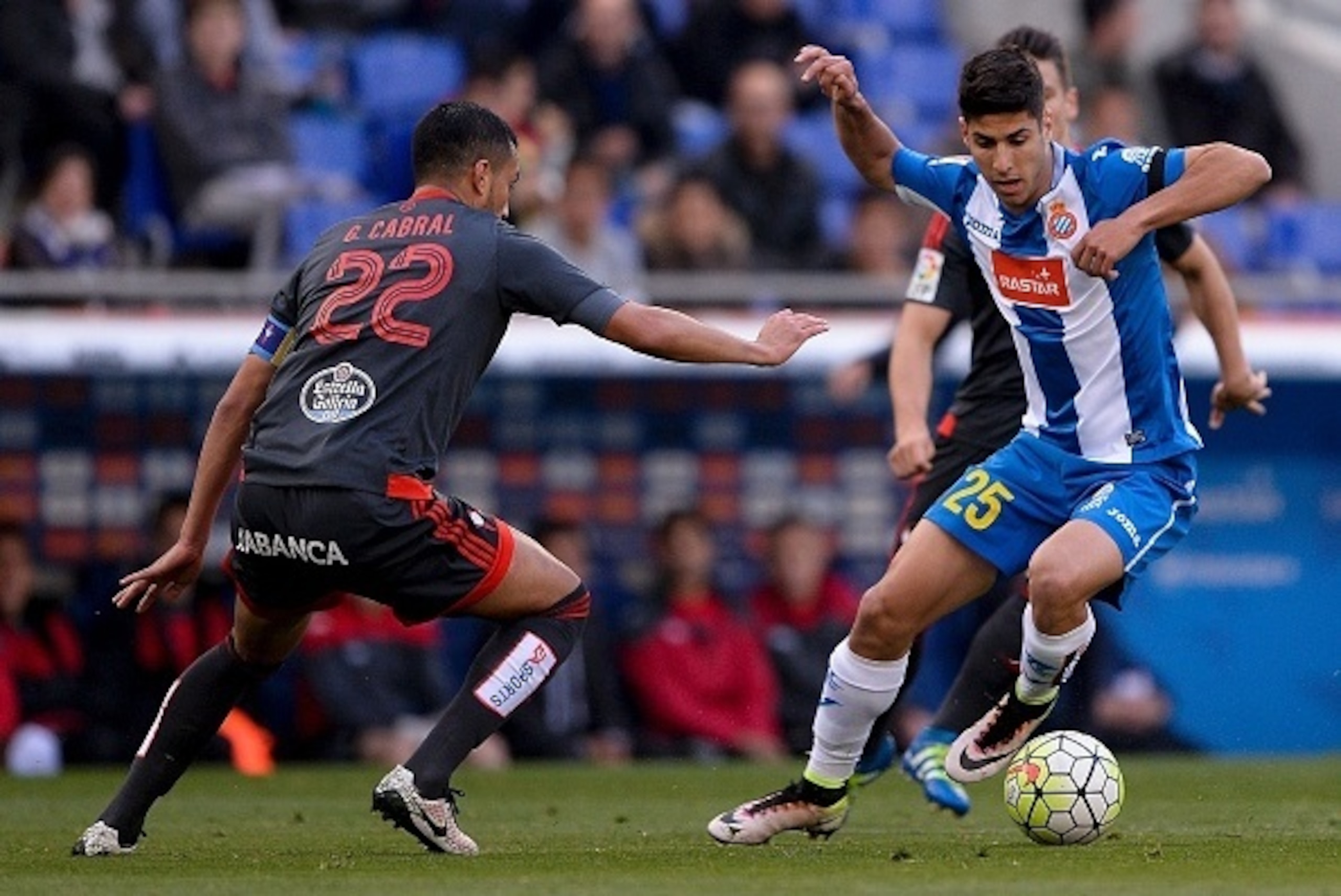 Celta's Argentinian defender Gustavo Cabral (L) vies with Espanyol's midfielder Marco Asensio during the Spanish league football match Real CD Espanyol vs RC Celta de Vigo at the Cornella-El Prat stadium in Cornella de Llobregat on April 19, 2016.  / AFP 