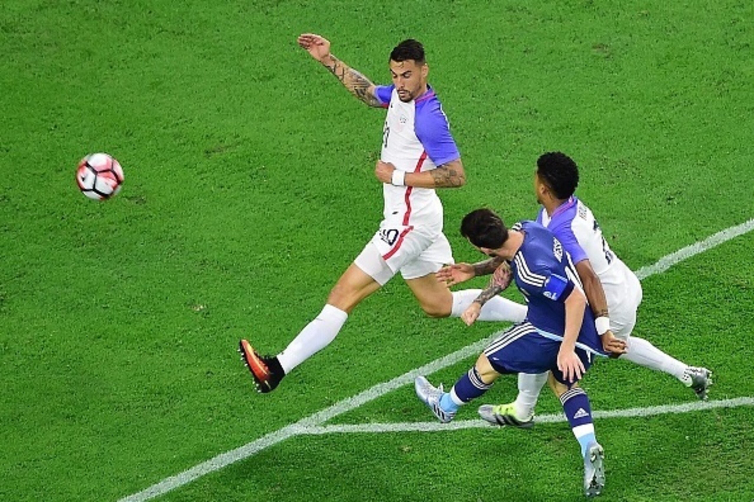 Argentina's Lionel Messi (in blue) tries to score past USA's Geoff Cameron (L) and Fabian Johnson during their Copa America Centenario semifinal football match in Houston, Texas, United States, on June 21, 2016.  / AFP / Frederic J. BROWN        (Photo cr