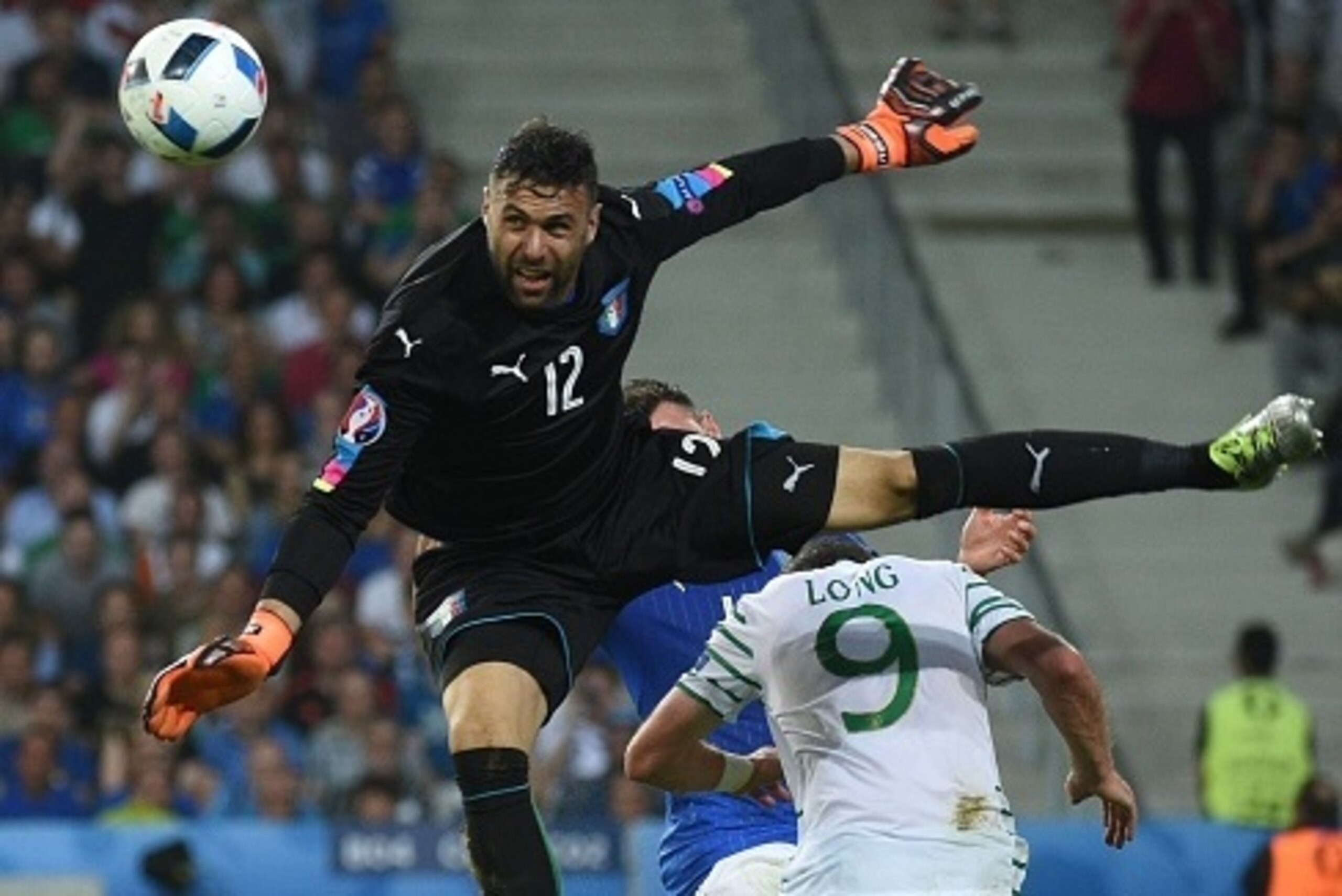 Italy's goalkeeper Salvatore Sirigu (top) and Ireland's forward Shane Long (R) vie for the ball during the Euro 2016 group E football match between Italy and Ireland at the Pierre-Mauroy stadium in Villeneuve-d'Ascq, near Lille, on June 22, 2016. / AFP / 