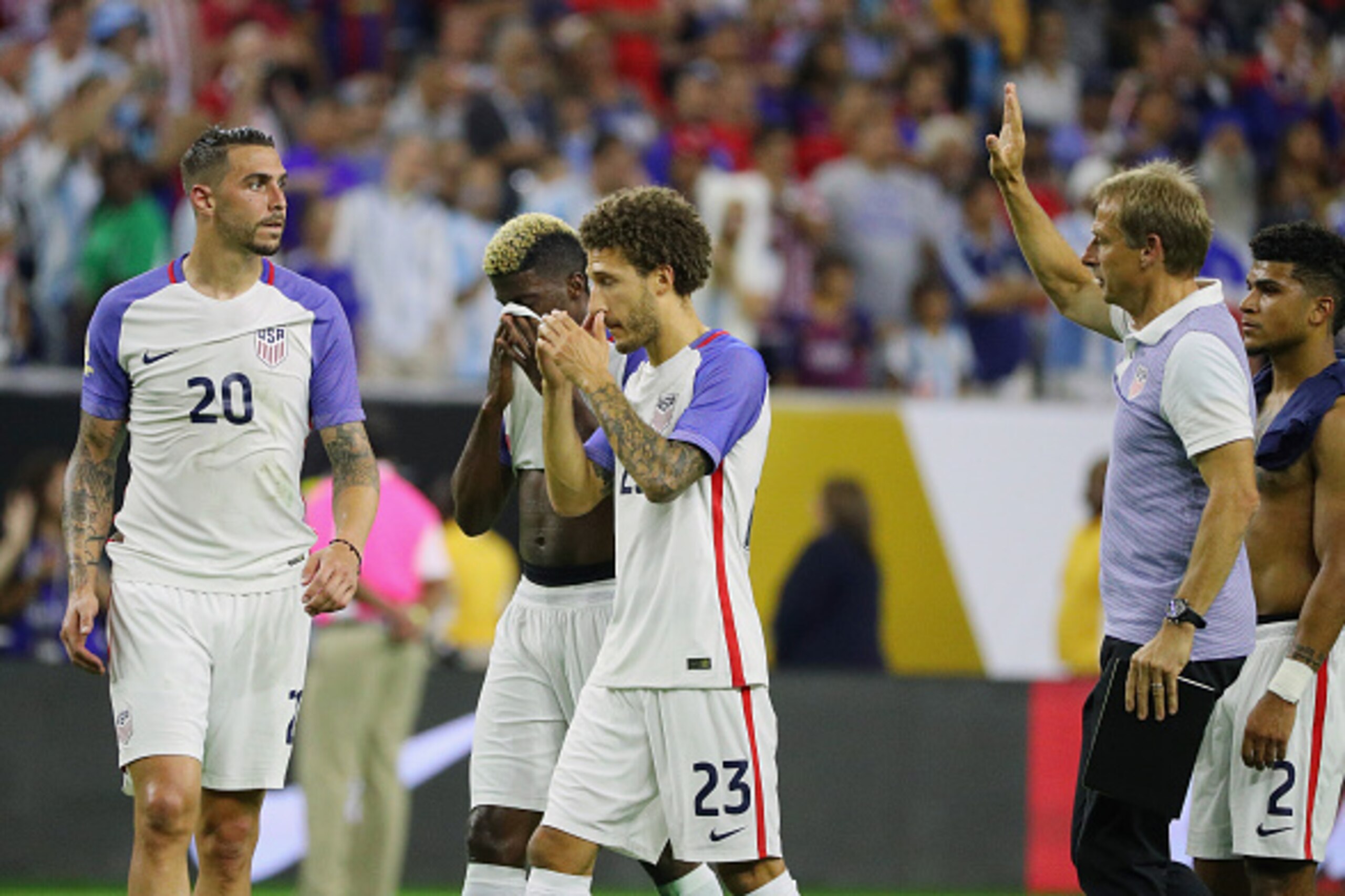 HOUSTON, TX - JUNE 21:  United States manager Jurgen Klinsmann (R) walks across the pitch with a group of players after losing their game against Argentina 4-0 during a 2016 Copa America Centenario Semifinal match at NRG Stadium on June 21, 2016 in Housto