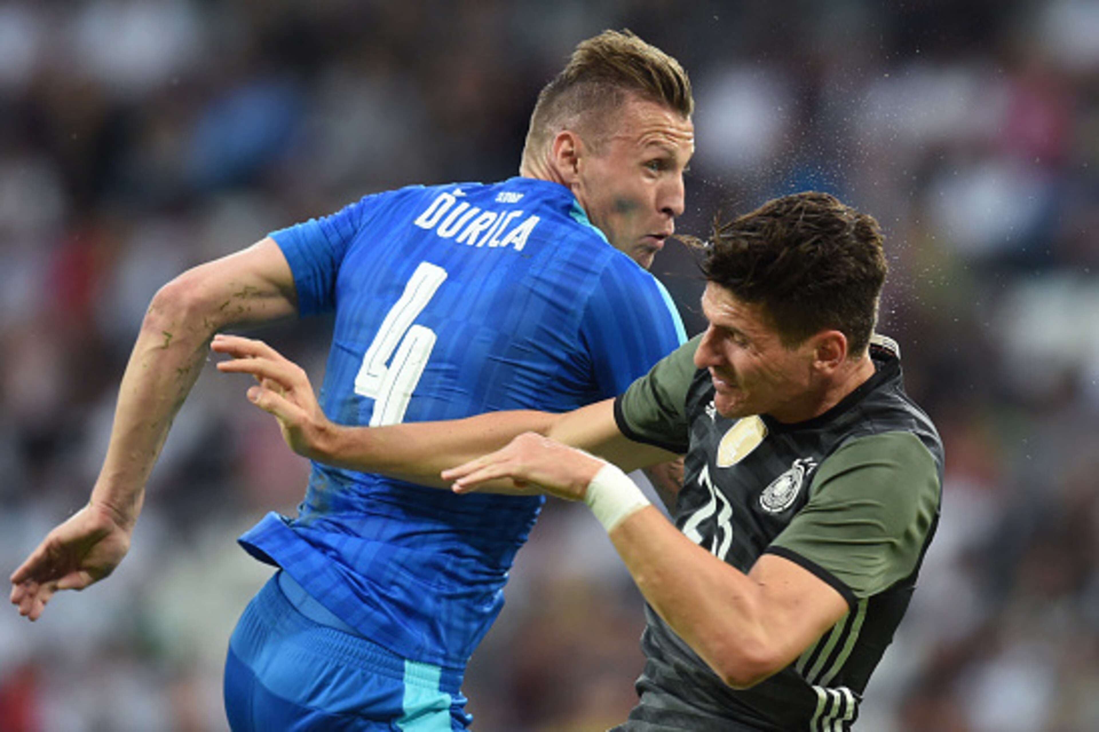 Augsburg's Slovakian defender Jan Durica (L) and Germany's forward Mario Gomez vie for the ball during the the friendly football match between Germany and Slovakia in Augsburg, southern Germany, on May 29, 2016.  / AFP / CHRISTOF STACHE        (Photo cred