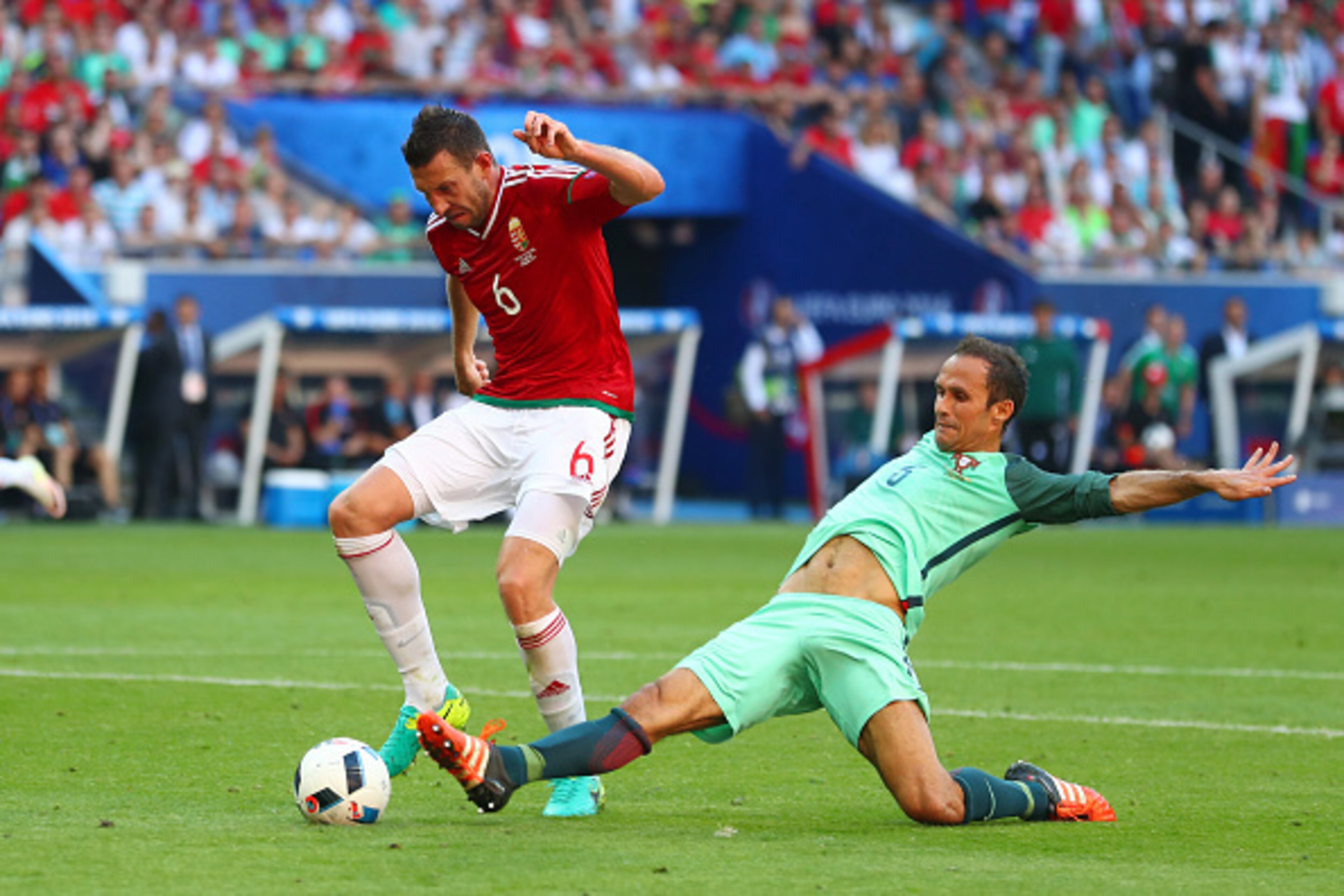 LYON, FRANCE - JUNE 22: Akos Elek of Hungary is tackled by Ricardo Carvalho of Portugal during the UEFA EURO 2016 Group F match between Hungary and Portugal at Stade des Lumieres on June 22, 2016 in Lyon, France.  (Photo by Julian Finney/Getty Images)