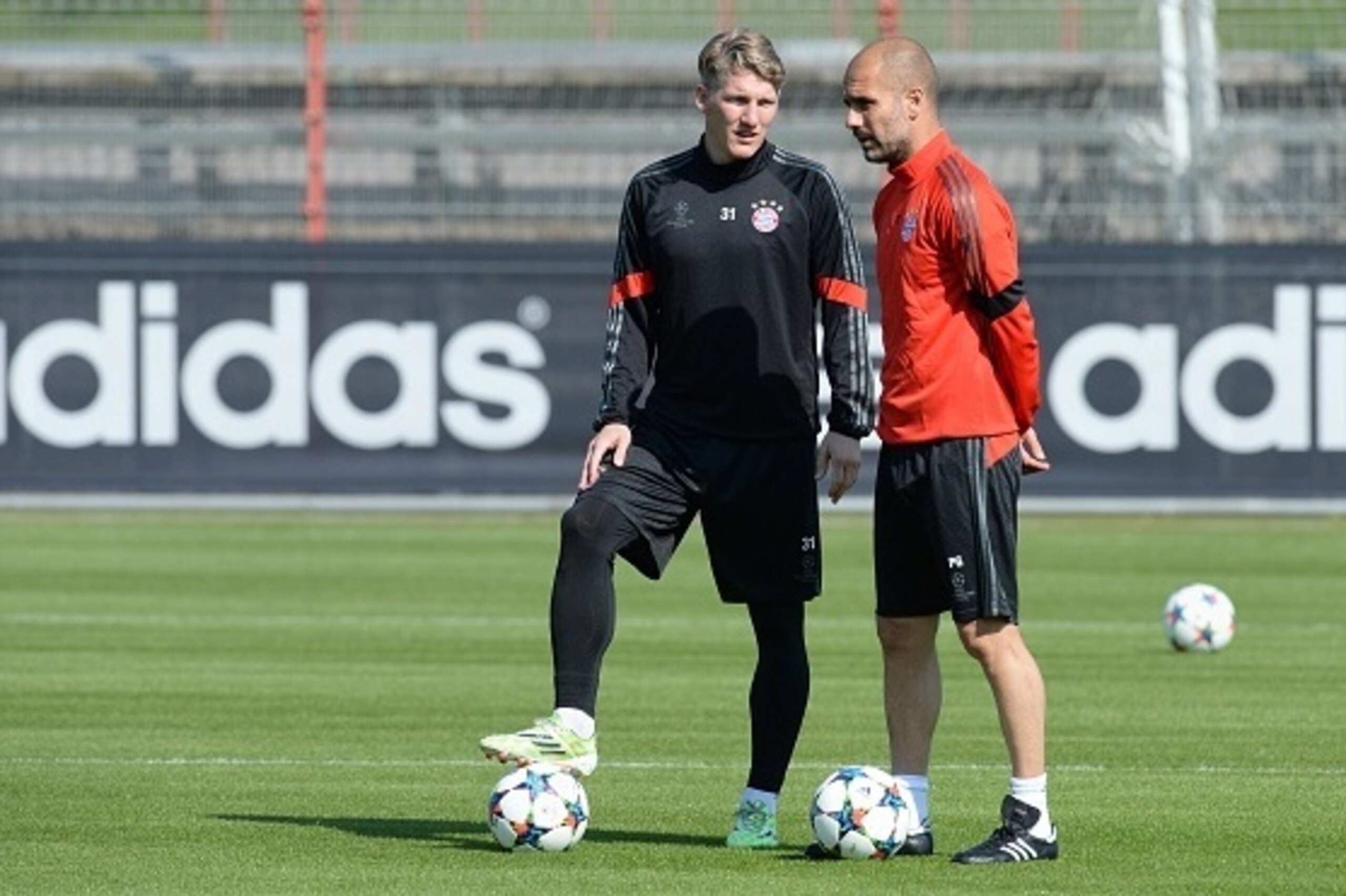 Bayern Munich's Spanish headcoach Pep Guardiola (R) and Bayern Munich's midfielder Bastian Schweinsteiger (L) speak during a training session in Munich, southern Germany on April 20, 2015, a day ahead of the UEFA Champions League quarter-final second leg 