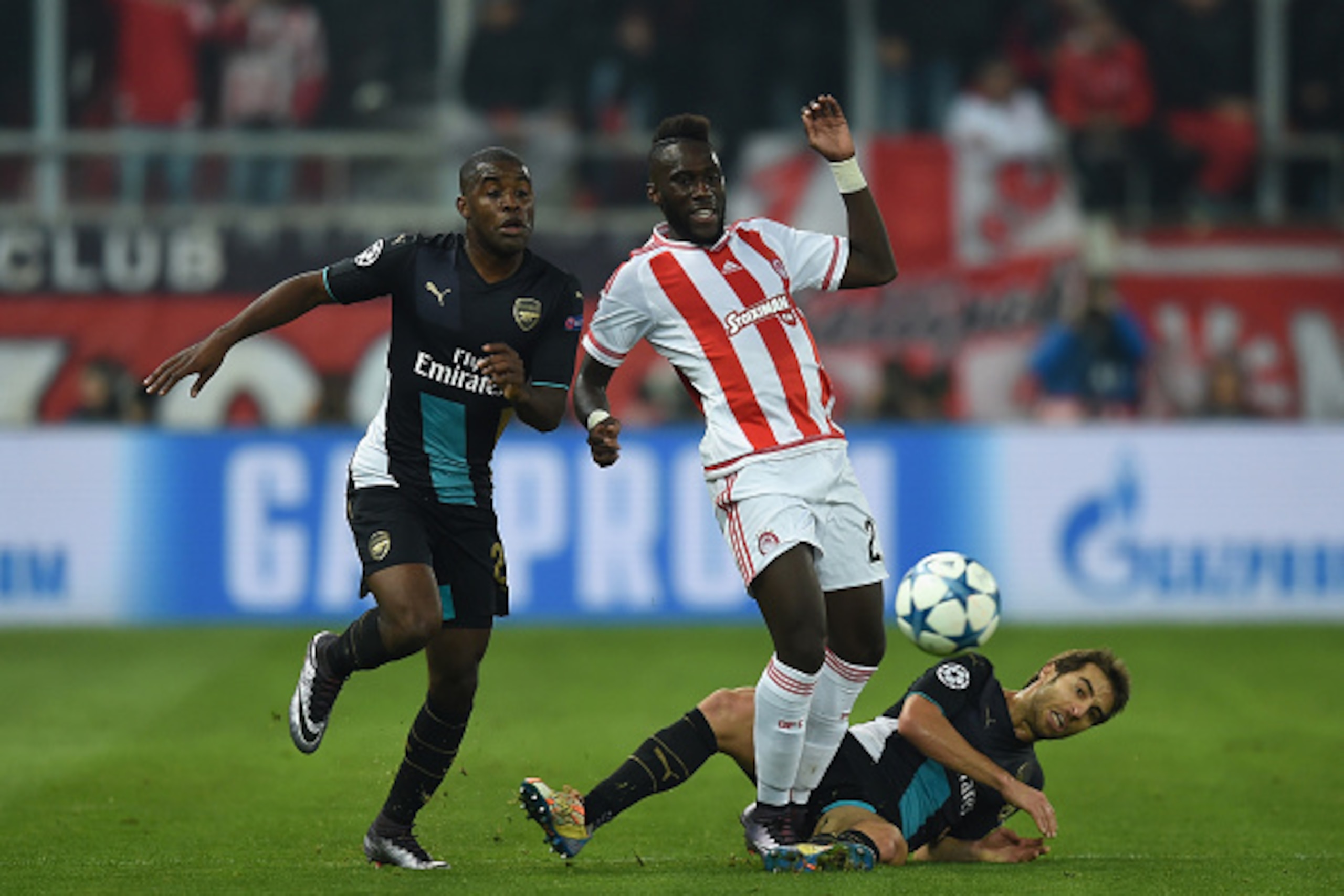 PIRAEUS, GREECE - DECEMBER 09:  Arthur Masuaku of Olympiakos battles for the ball with Mathieu Flamini of Arsenal and Joel Campbell of Arsenal during the UEFA Champions League Group F match between Olympiacos FC and Arsenal FC at Karaiskakis Stadium on De