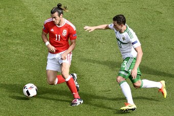 Wales' forward Gareth Bale (L) in action against Northern Ireland's midfielder Corry Evans during the Euro 2016 round of sixteen football match Wales vs Northern Ireland, on June 25, 2016 at the Parc des Princes stadium in Paris. / AFP / PHILIPPE LOPEZ   