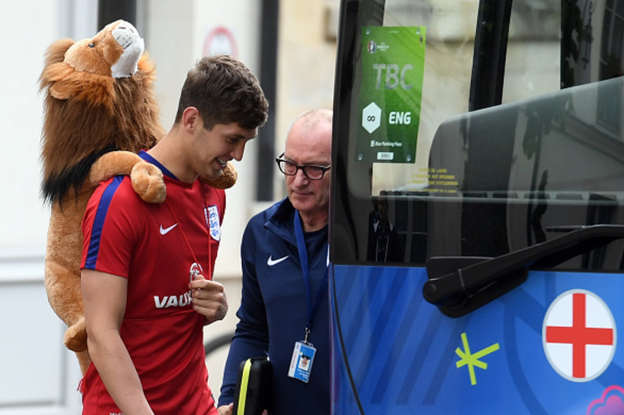 England's defender John Stones boards the team bus with the team lion mascot to attend a training session in Chantilly, on June 14, 2016 during the Euro 2016 football tournament. / AFP / PAUL ELLIS        (Photo credit should read PAUL ELLIS/AFP/Getty Ima