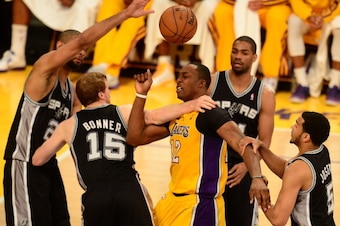 Dwight Howard (C) of the Los Angeles Lakers loses control of the ball under pressure from the San Antonio Spurs during Game Three of the NBA Western Conference Quarterfinal Playoffs at Staples Center in Los Angeles, California on April 26, 2013. AFP PHOTO