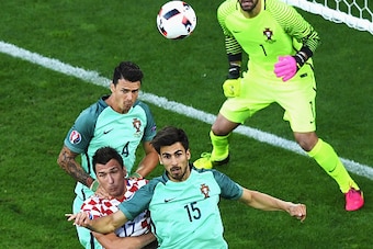 LENS, FRANCE - JUNE 25: Mario Mandzukic (C) of Croatia competes for the ball against  Jose Fonte (L) and Andre Gomes (R) of Portugal during the UEFA EURO 2016 round of 16 match between Croatia and Portugal at Stade Bollaert-Delelis on June 25, 2016 in Len