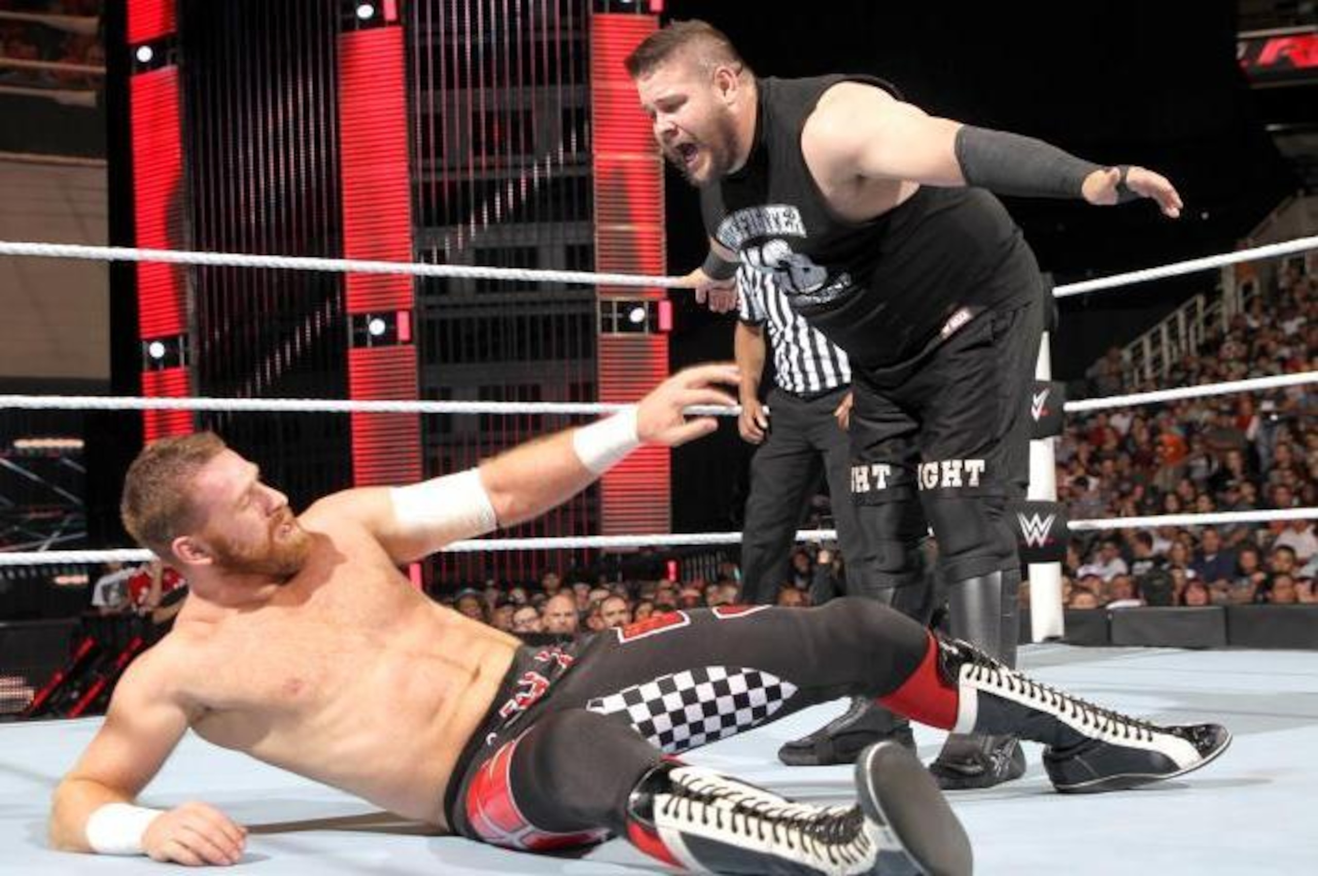 Kevin Owens towers over a fallen Sami Zayn. Kevin Owens towers over a fallen Sami Zayn.