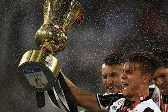 Juventus' forward from Argentina Paulo Dybala celebrates with the trophy after winning the Italian Tim Cup final football match AC Milan vs Juventus on May 21, 2016 at the Olympic Stadium in Rome.  Juventus won 0-1 in the extra time.    AFP PHOTO / FILIPP