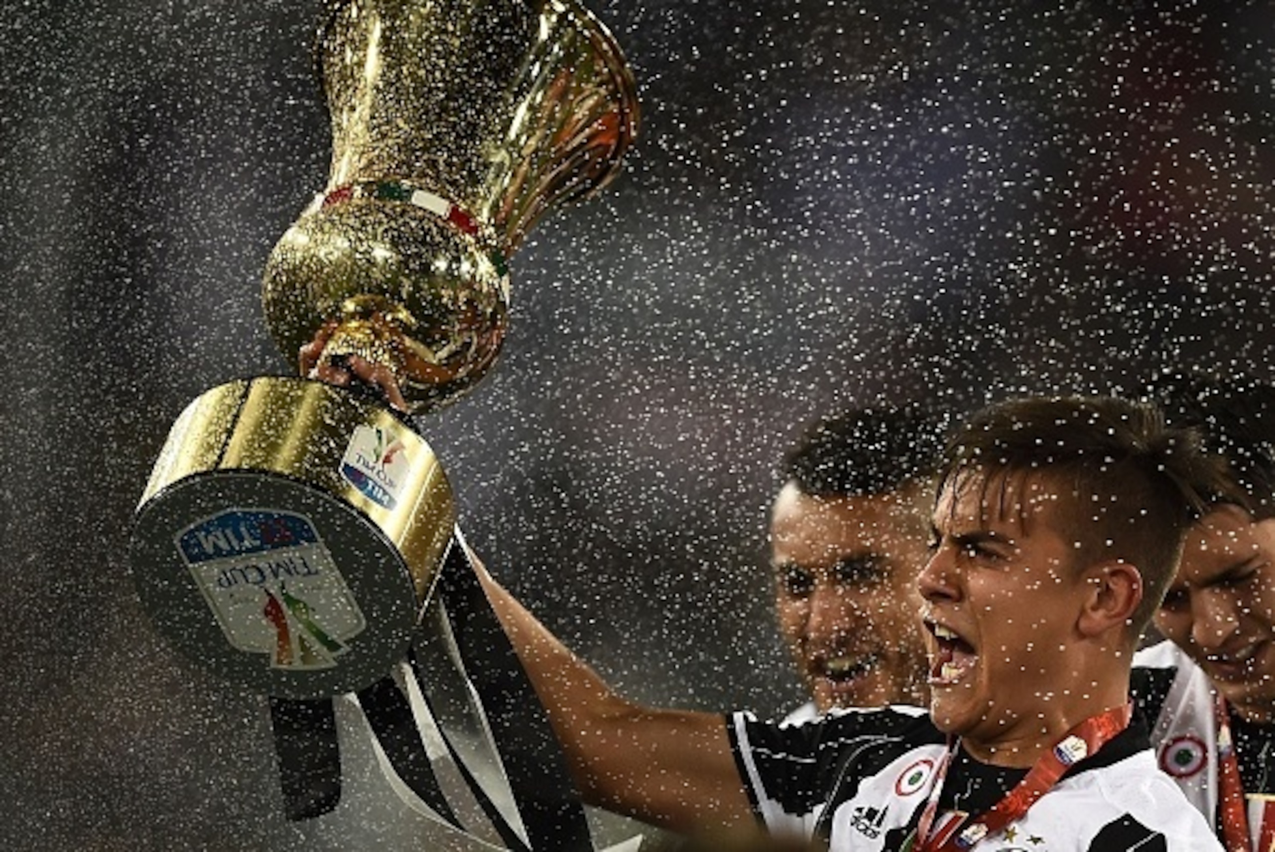 Juventus' forward from Argentina Paulo Dybala celebrates with the trophy after winning the Italian Tim Cup final football match AC Milan vs Juventus on May 21, 2016 at the Olympic Stadium in Rome.  Juventus won 0-1 in the extra time.    AFP PHOTO / FILIPP