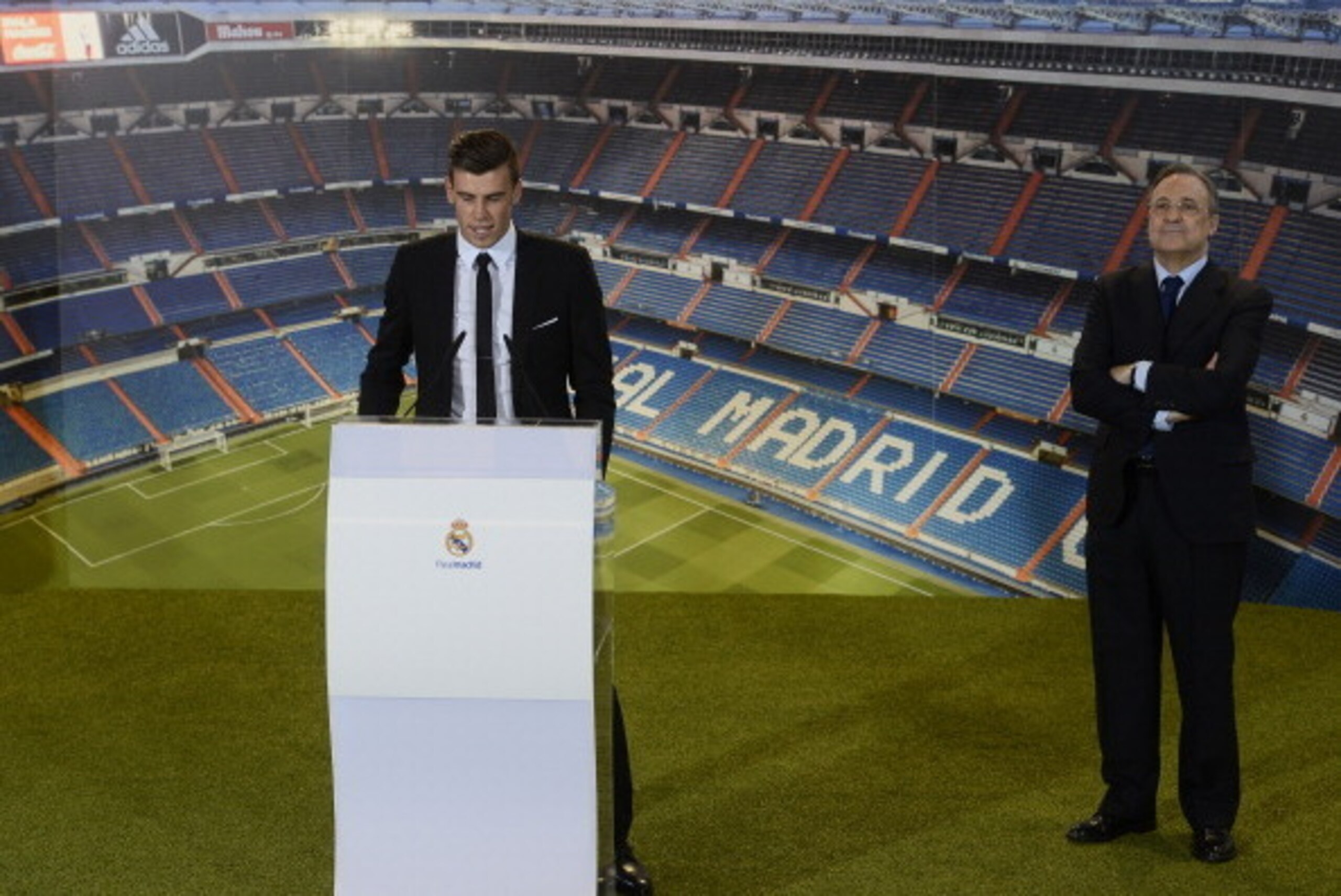 New Welsh striker Gareth Bale of Real Madrid (L) delivers a speech past Real Madrid's President Florentino Perez during his presentation at the Santiago Bernabeu stadium in Madrid on September 2, 2013. Bale was unveiled as a Real Madrid player today after