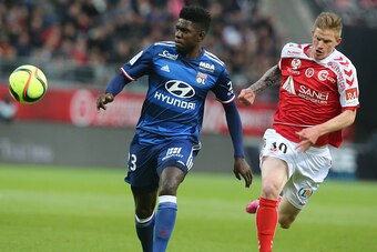 Reims' French forward Gaetan Charbonnier (R) vies with Lyon's French Cameroonian defender Samuel Umtiti (L) during the French Ligue 1 football match between Reims and Lyon on May 14, 2016 at the Auguste Delaune Stadium in Reims. PHOTO AFP / FRANCOIS NASCI