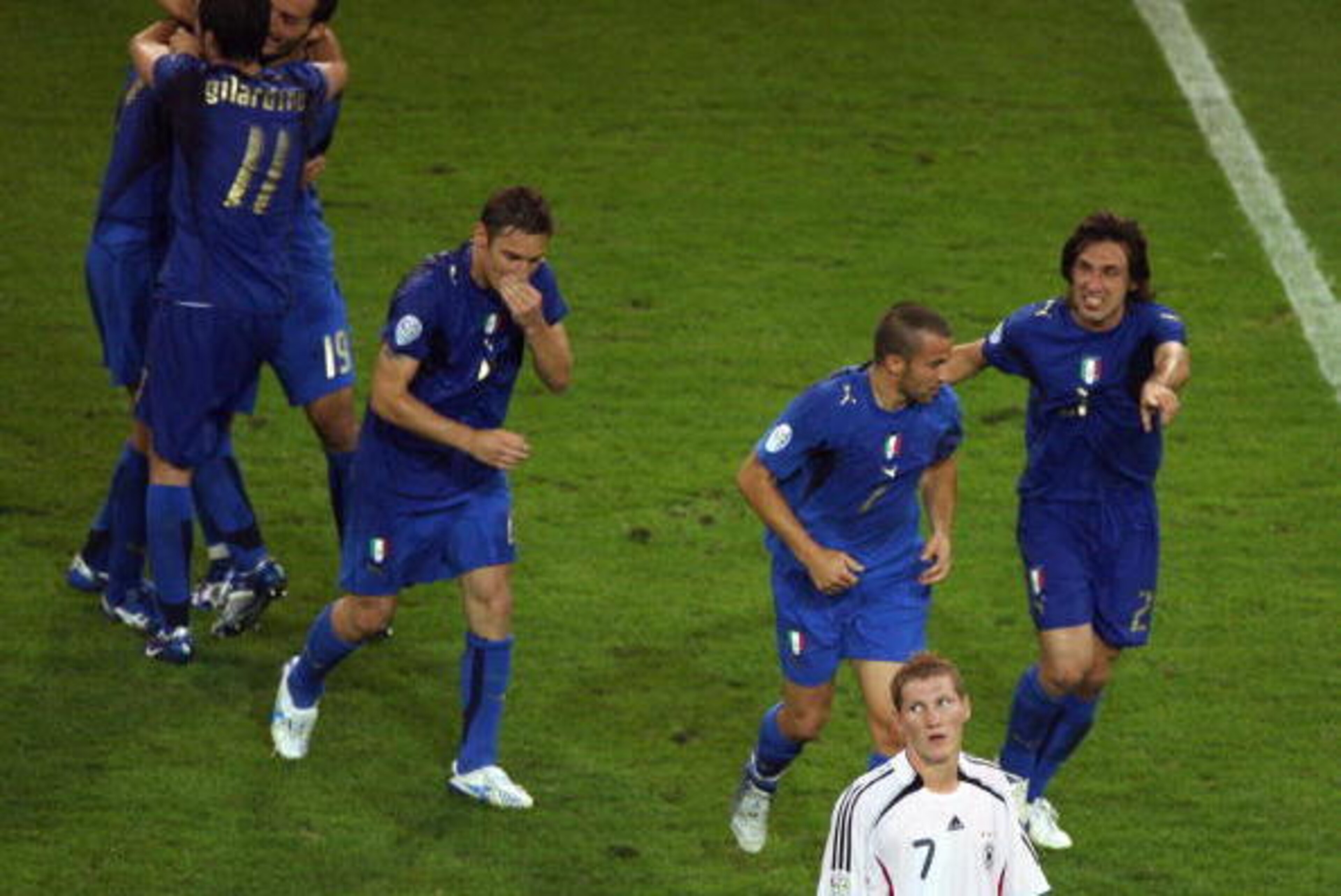 Dortmund, GERMANY:  Italian players celebrate next to German midfielder Bastian Schweinsteiger (white jersey) at the end of the World Cup 2006 semi final football game Germany vs. Italy, 04 July 2006 at Dortmund stadium. Italy won 2 to 0 after extra-time.