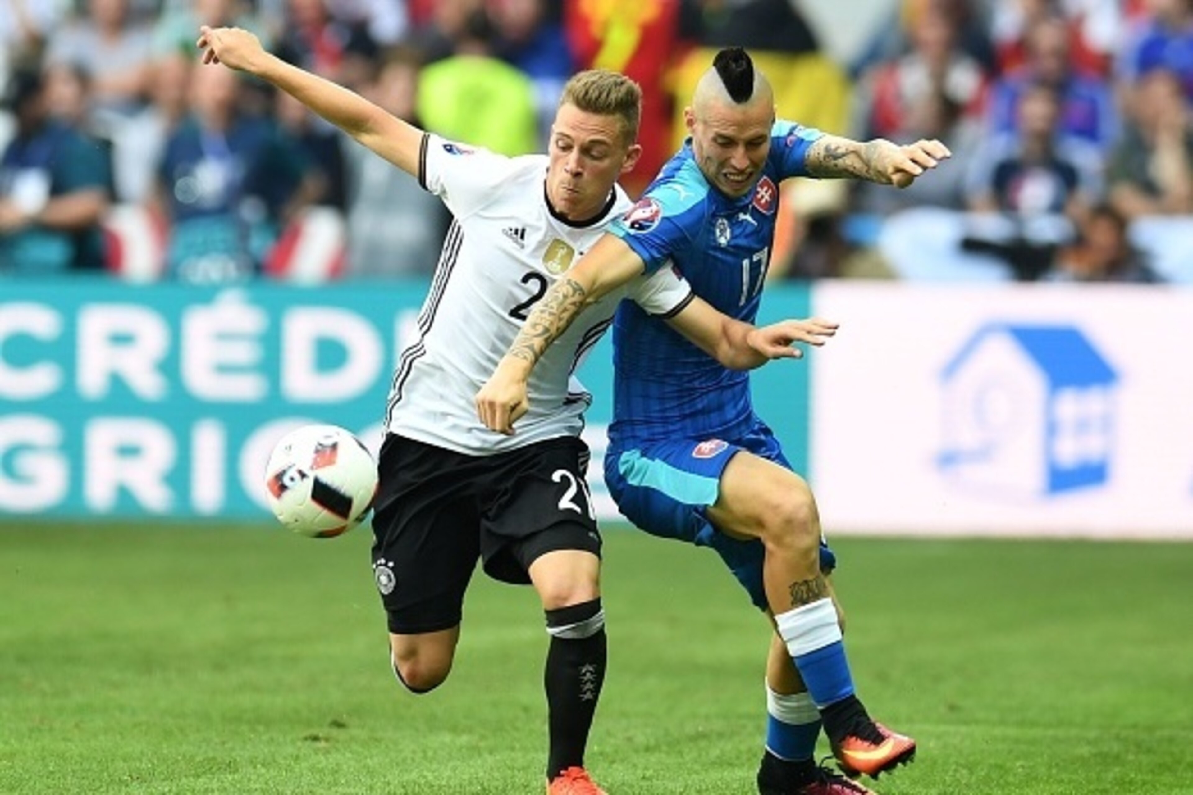 Slovakia's midfielder Marek Hamsik (R) challenges Germany's midfielder Joshua Kimmich during the Euro 2016 round of 16 football match between Germany and Slovakia at the Pierre-Mauroy stadium in Villeneuve-d'Ascq near Lille on June 26, 2016. / AFP / PATRI