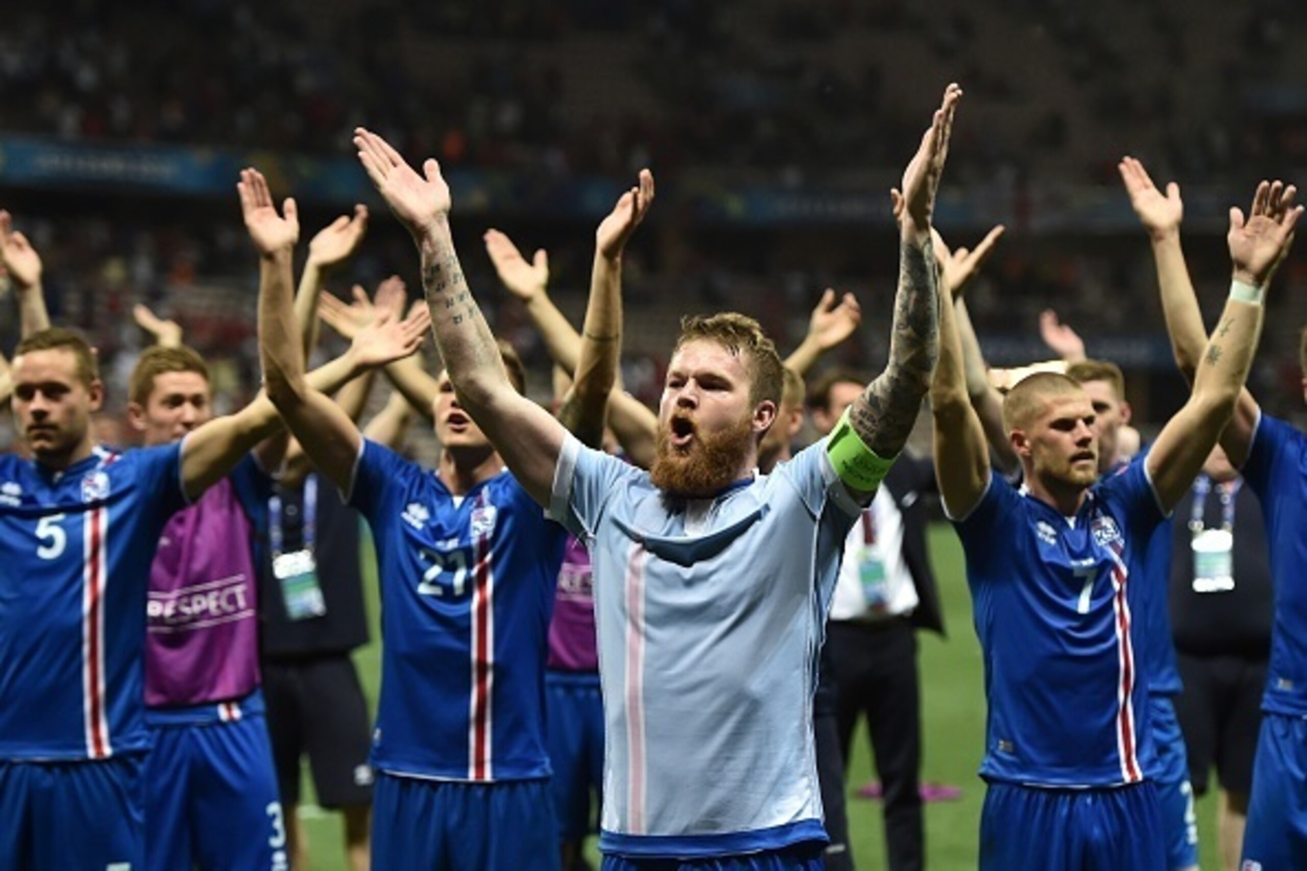 Iceland's midfielder Aron Gunnarsson and other players celebrate their team's win after the Euro 2016 round of 16 football match between England and Iceland at the Allianz Riviera stadium in Nice on June 27, 2016.  
Iceland won the match 1-2. / AFP / BERT