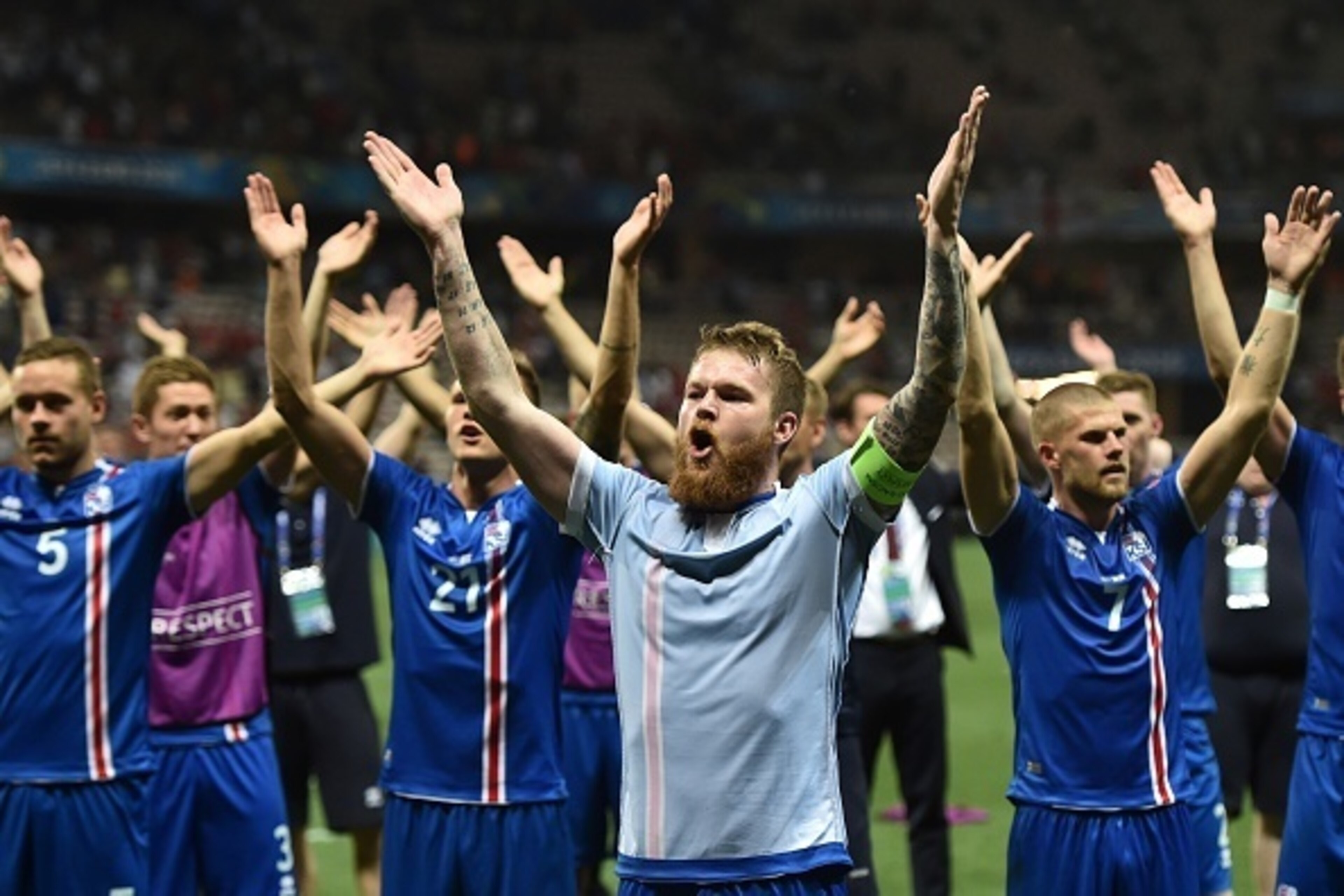 Iceland's midfielder Aron Gunnarsson and other players celebrate their team's win after the Euro 2016 round of 16 football match between England and Iceland at the Allianz Riviera stadium in Nice on June 27, 2016.  
Iceland won the match 1-2. / AFP / BERT