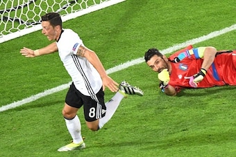 Germany's midfielder Mesut Oezil celebrates after scoring in the nets of Italy's goalkeeper Gianluigi Buffon during the Euro 2016 quarter-final football match between Germany and Italy at the Matmut Atlantite stadium in Bordeaux on July 2, 2016.
 / AFP / 