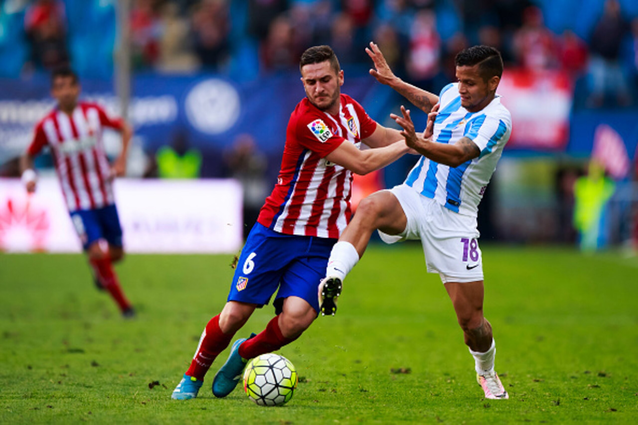 MADRID, SPAIN - APRIL 23: Koke (L) of Atletico de Madrid competes for the ball with Roberto Rosales (R) of Malaga CF during the La Liga match between Club Atletico de Madrid and Malaga CF at Vicente Calderon Stadium on April 23, 2016 in Madrid, Spain.  (P