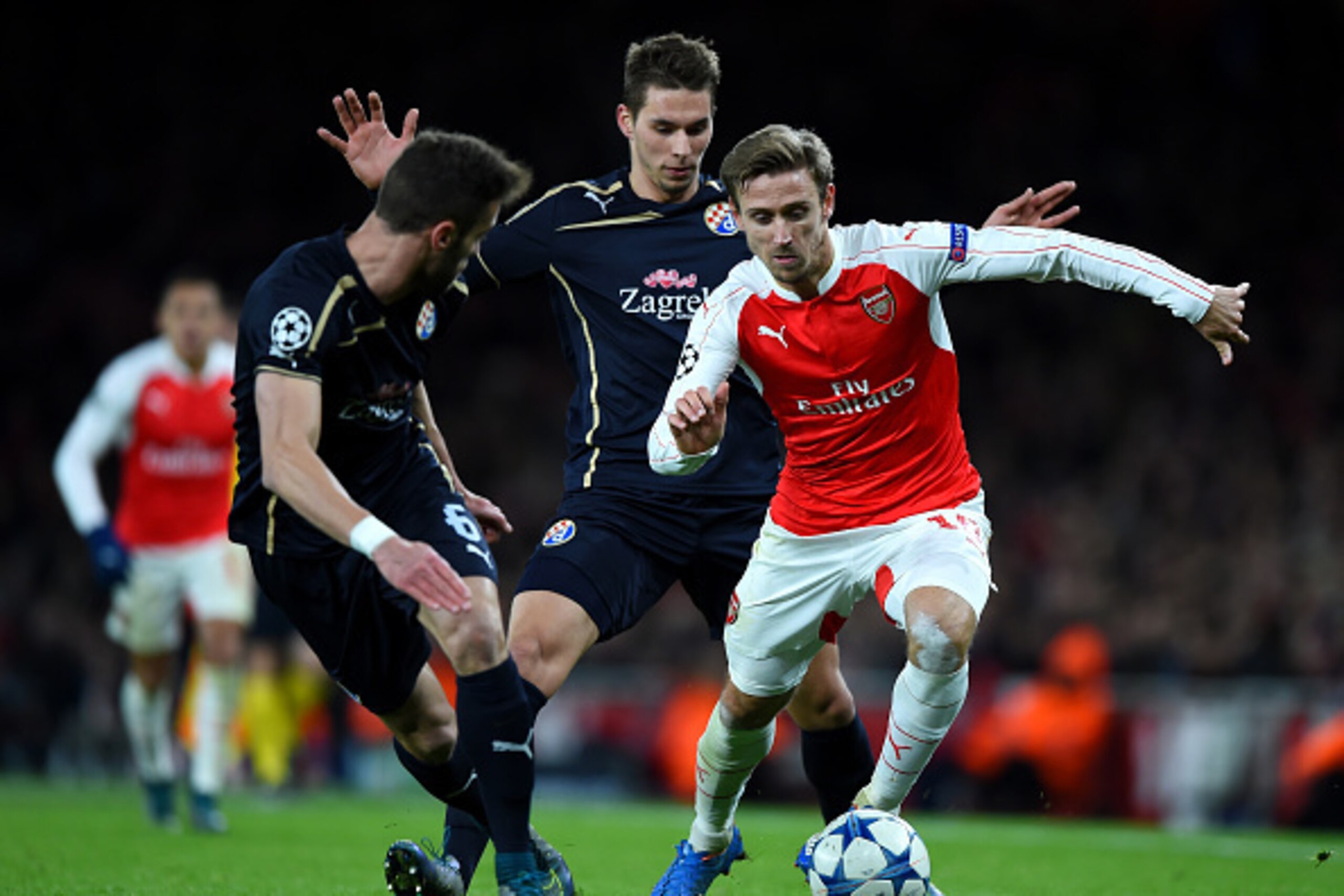 LONDON, ENGLAND - NOVEMBER 24: Nacho Monreal of Arsenal (r) takes on Ivo Pinto of Dinamo Zagreb and Marko Pjaca of Dinamo Zagreb during the UEFA Champions League match between Arsenal FC and GNK Dinamo Zagreb at Emirates Stadium on November 24, 2015 in L LONDON, ENGLAND - NOVEMBER 24: Nacho Monreal of Arsenal (r) takes on Ivo Pinto of Dinamo Zagreb and Marko Pjaca of Dinamo Zagreb during the UEFA Champions League match between Arsenal FC and GNK Dinamo Zagreb at Emirates Stadium on November 24, 2015 in L