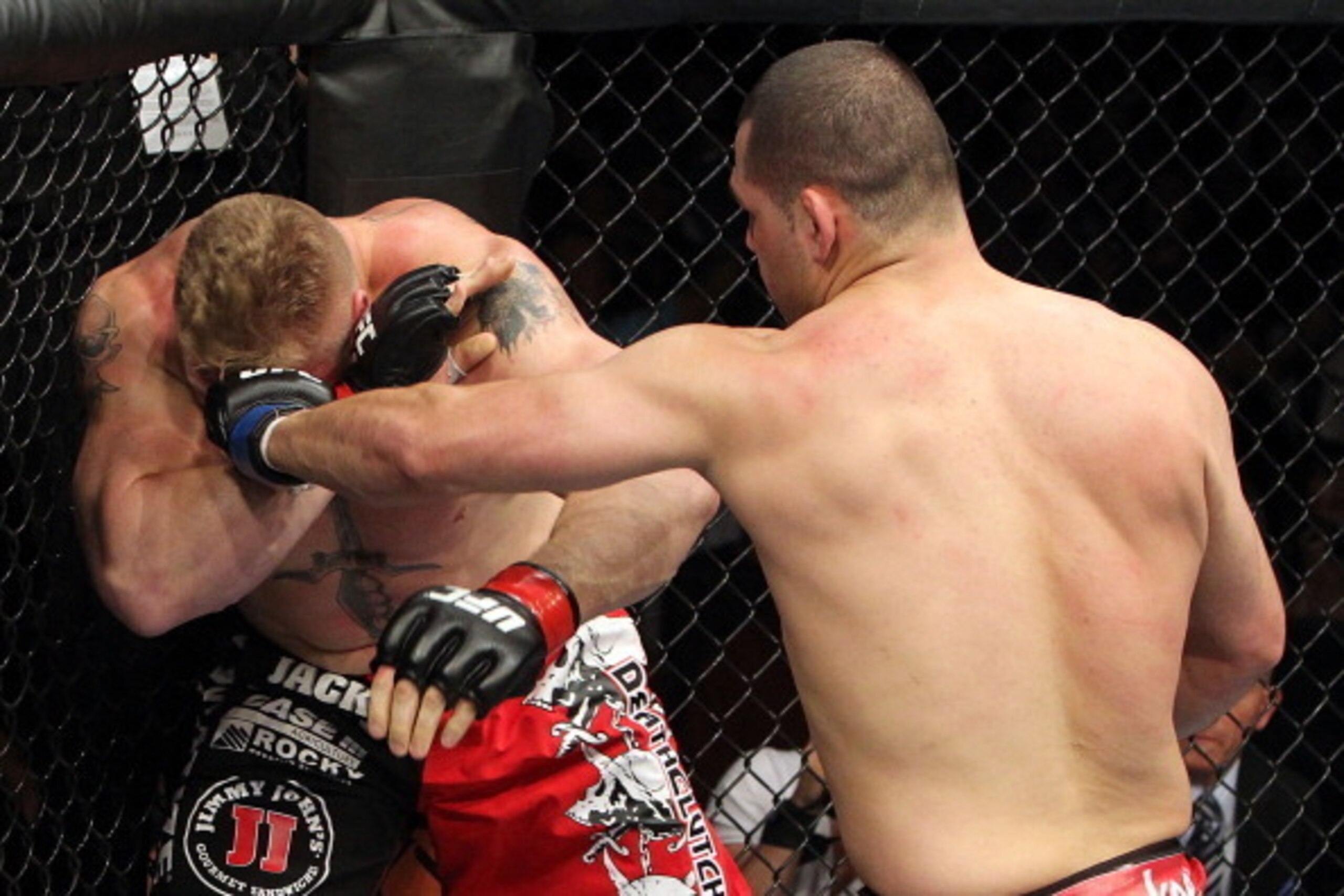 ANAHEIM, CA - OCTOBER 23:  (R-L) Cain Velasquez connects on a left to the face of Brock Lesnar in the first round during the heavyweight title bout during UFC 121 on October 23, 2010 in Anaheim, California. Velasquez defeated Lenar by first round TKO to b