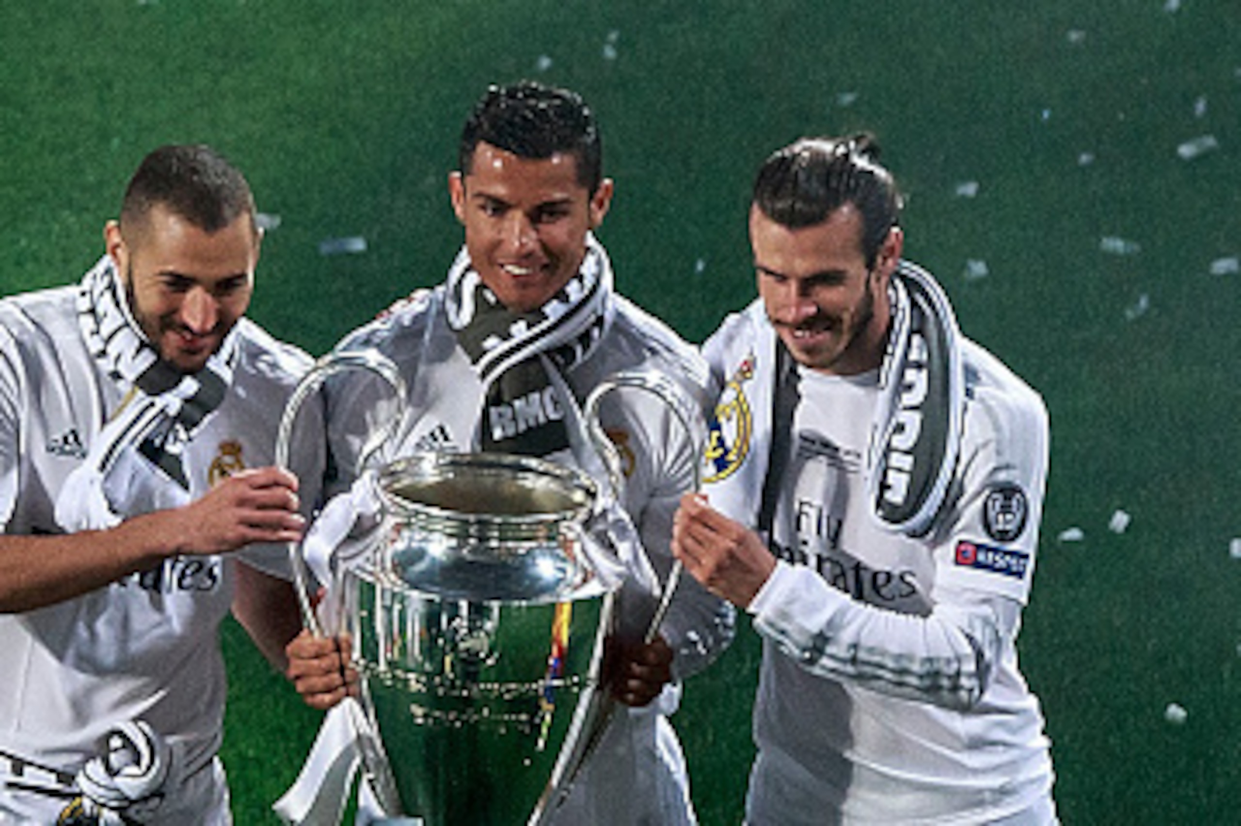 MADRID, SPAIN - MAY 29: Cristiano Ronaldo (2ndL) of Real Madrid CF holds the trophy as he poses for a picture with his teammates Karim Benzema (L) and Gareth Bale (R) during the celebration with their fans at Santiago Bernabeu Stadium the day after winnin