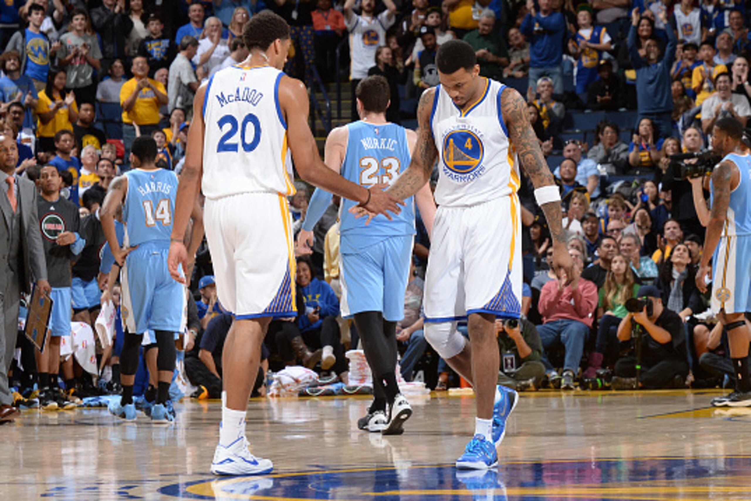 OAKLAND, CA - JANUARY 19: James Michael McAdoo #20 and Brandon Rush #4 of the Golden State Warriors celebrate during a game against the Denver Nuggets on January 19, 2015 at Oracle Arena in Oakland, California. NOTE TO USER: User expressly acknowledges an