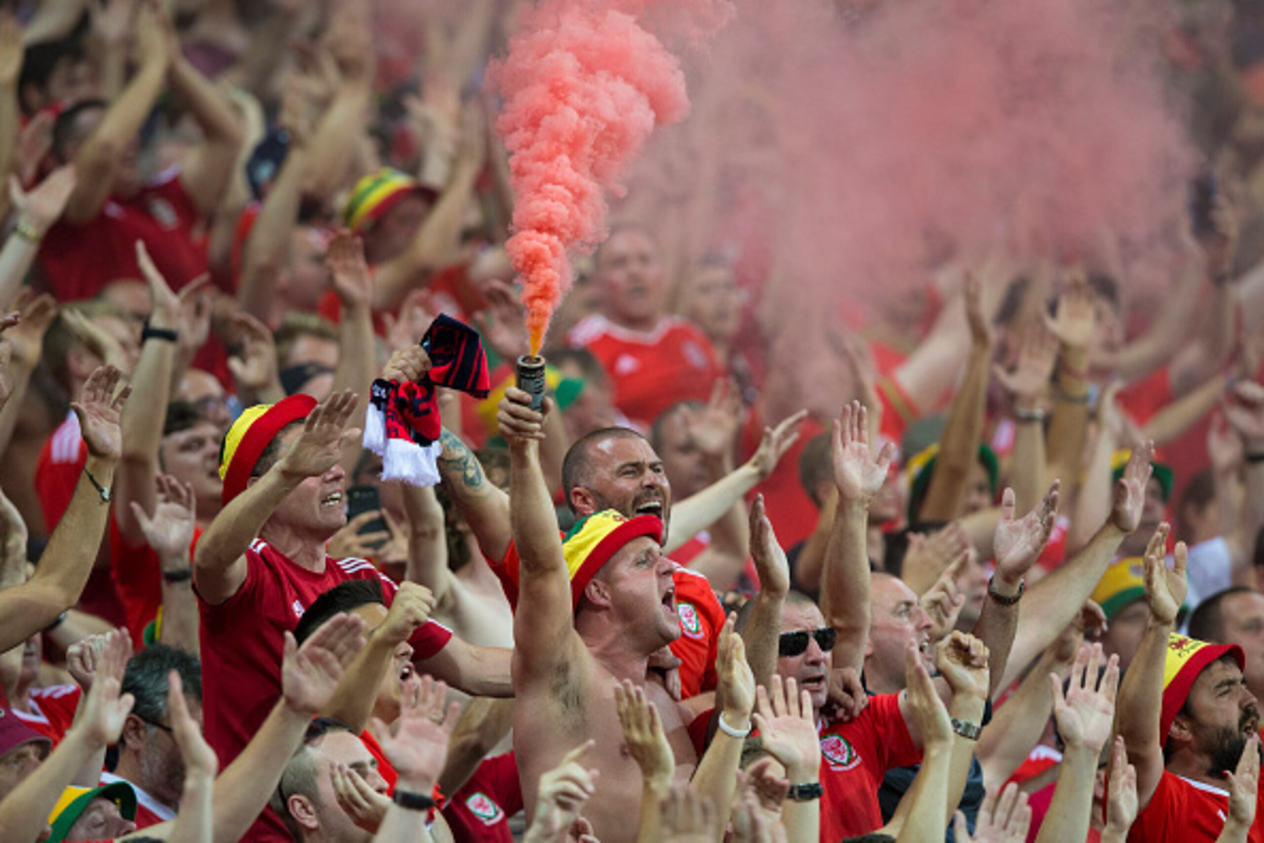 LYON, FRANCE - JULY 06: Wales fans light a flare at full time during the UEFA Euro 2016 Semi-final match between Portugal and Wales at Stade de Lyon on July 06 in Lyon, France. (Photo by Craig Mercer/CameraSport via Getty Images) LYON, FRANCE - JULY 06: Wales fans light a flare at full time during the UEFA Euro 2016 Semi-final match between Portugal and Wales at Stade de Lyon on July 06 in Lyon, France. (Photo by Craig Mercer/CameraSport via Getty Images)