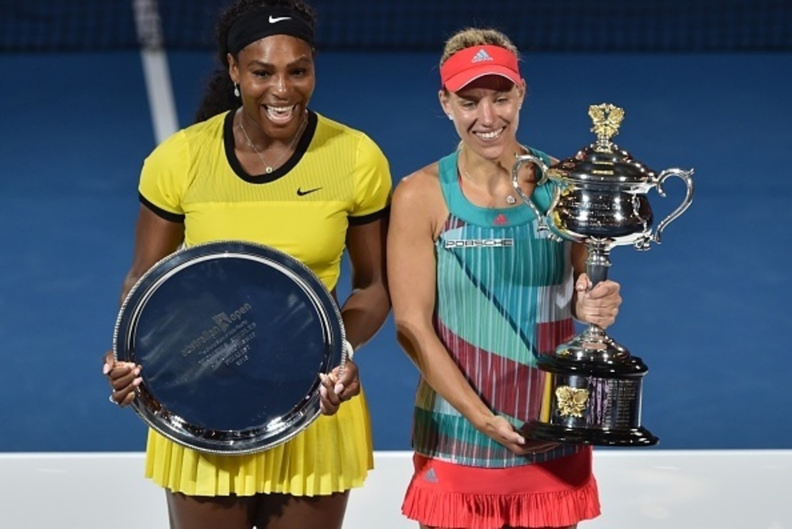 Angelique Kerber of Germany (R) holds the winner's trophy during the awards ceremony following her victory over Serena Williams of the US (L) in their women's singles final match on day 13 of the 2016 Australian Open tennis tournament in Melbourne on Janu