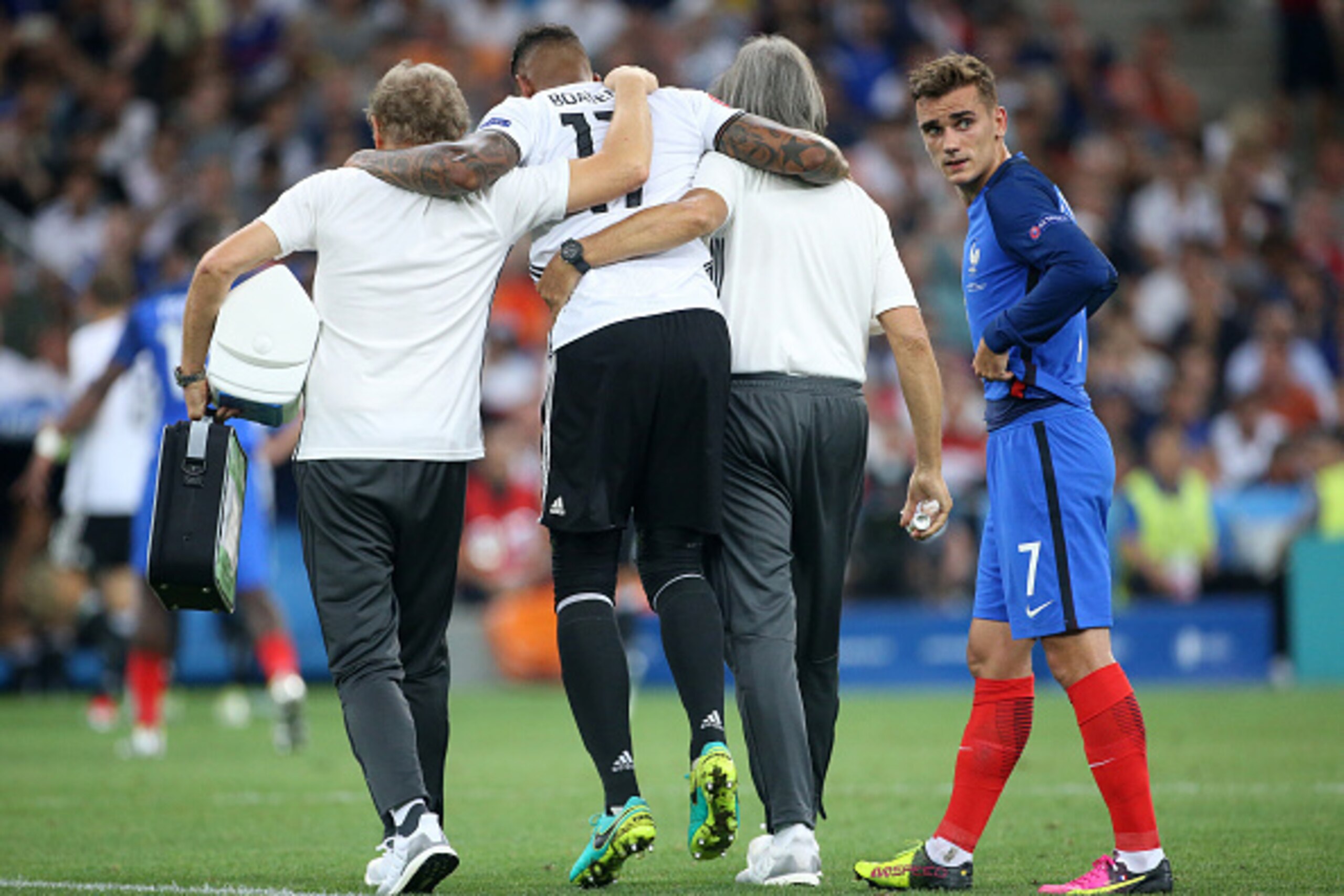 MARSEILLE, FRANCE - JULY 7: Injured, Jerome Boateng leaves the pitch while Antoine Griezmann of France looks on during the UEFA Euro 2016 semi-final match between Germany and France at Stade Velodrome on July 7, 2016 in Marseille, France. (Photo by Jean C