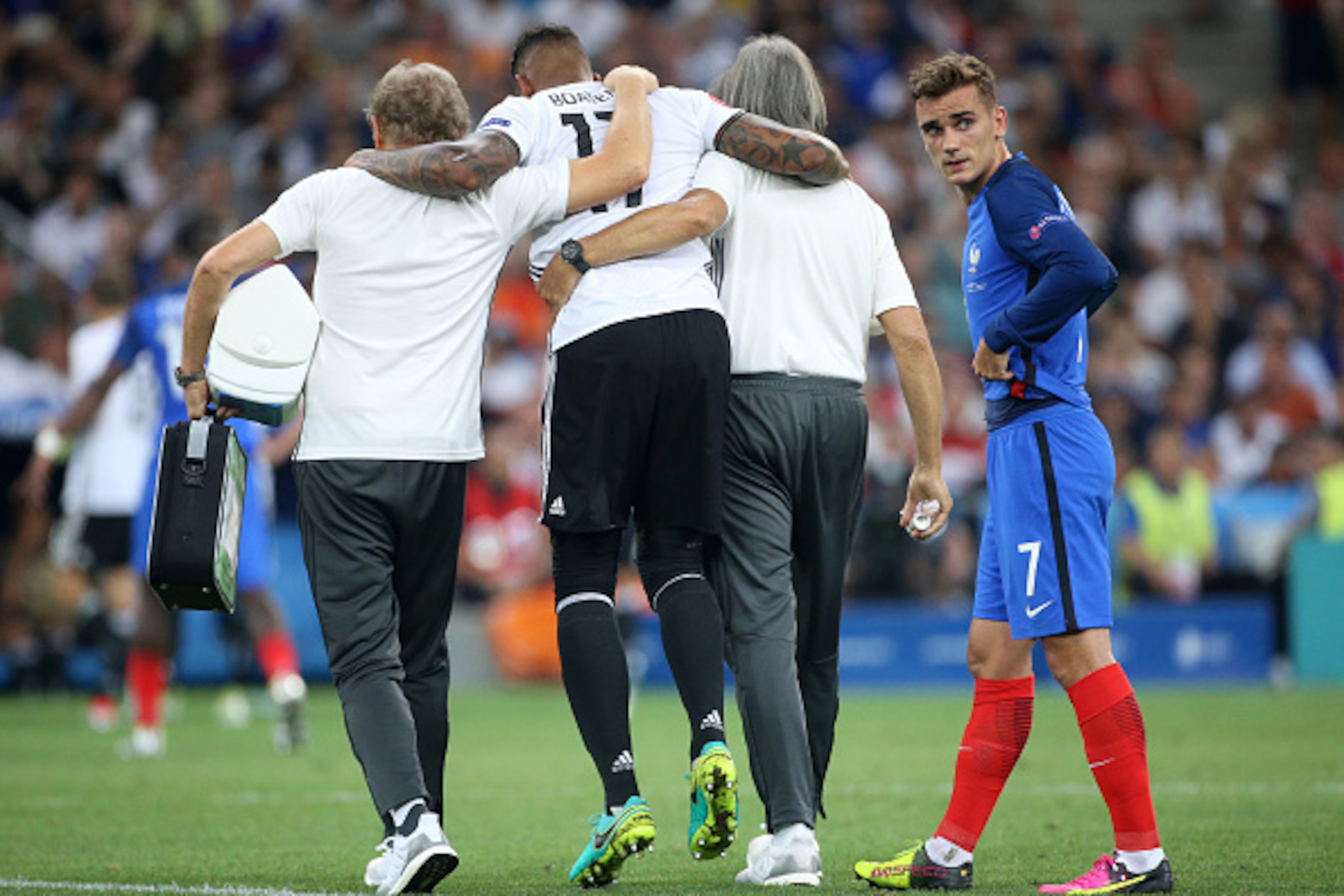 MARSEILLE, FRANCE - JULY 7: Injured, Jerome Boateng leaves the pitch while Antoine Griezmann of France looks on during the UEFA Euro 2016 semi-final match between Germany and France at Stade Velodrome on July 7, 2016 in Marseille, France. (Photo by Jean C