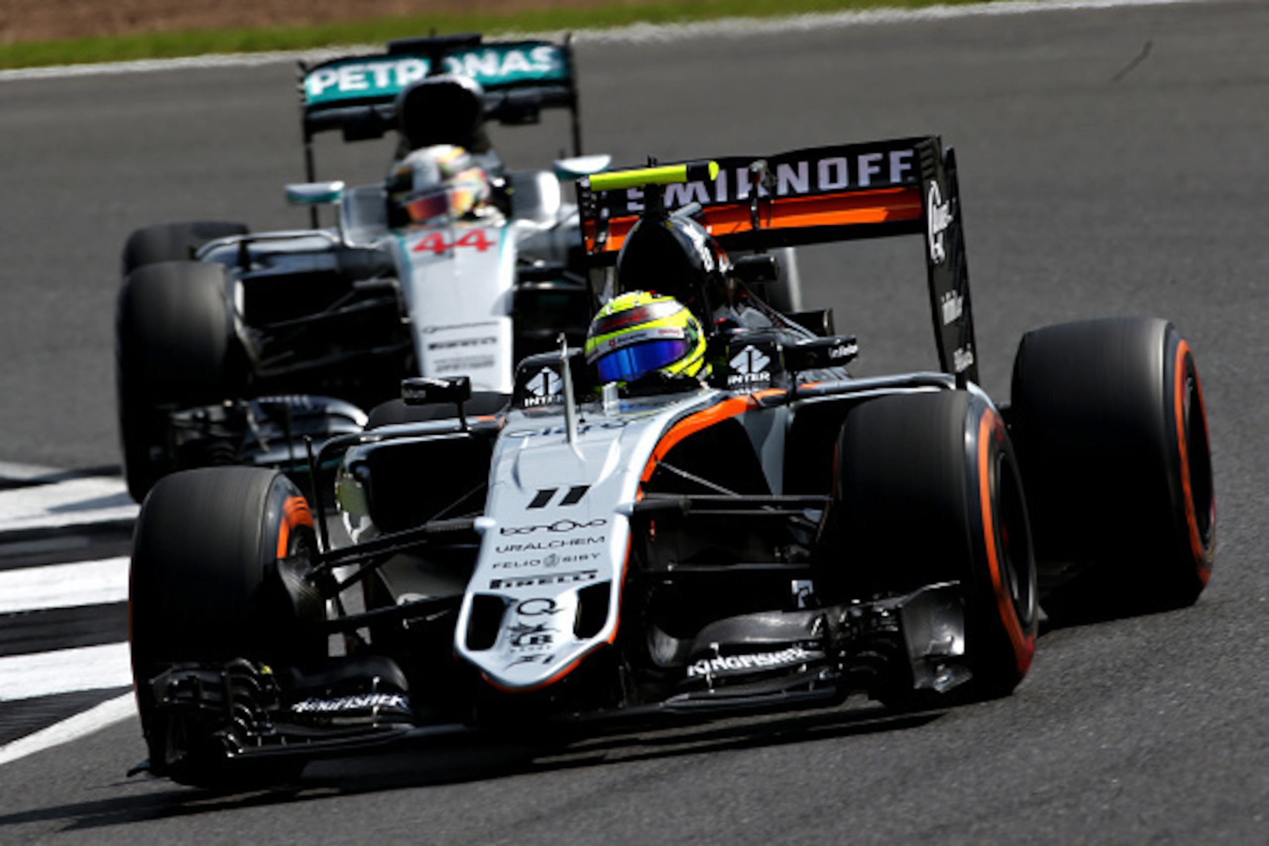 NORTHAMPTON, ENGLAND - JULY 08: Sergio Perez of Mexico driving the (11) Sahara Force India F1 Team VJM09 Mercedes PU106C Hybrid turbo on track ahead of Lewis Hamilton of Great Britain driving the (44) Mercedes AMG Petronas F1 Team Mercedes F1 WO7 Mercedes