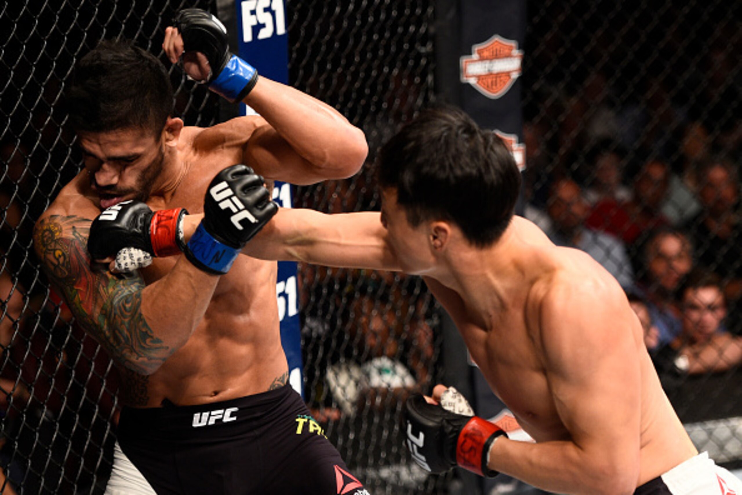 LAS VEGAS, NV - JULY 08:  (R-L) Doo Ho Choi of South Korea knocks down Thiago Tavares of Brazil with a punch in their featherweight bout during The Ultimate Fighter Finale event at MGM Grand Garden Arena on July 8, 2016 in Las Vegas, Nevada.  (Photo by Je