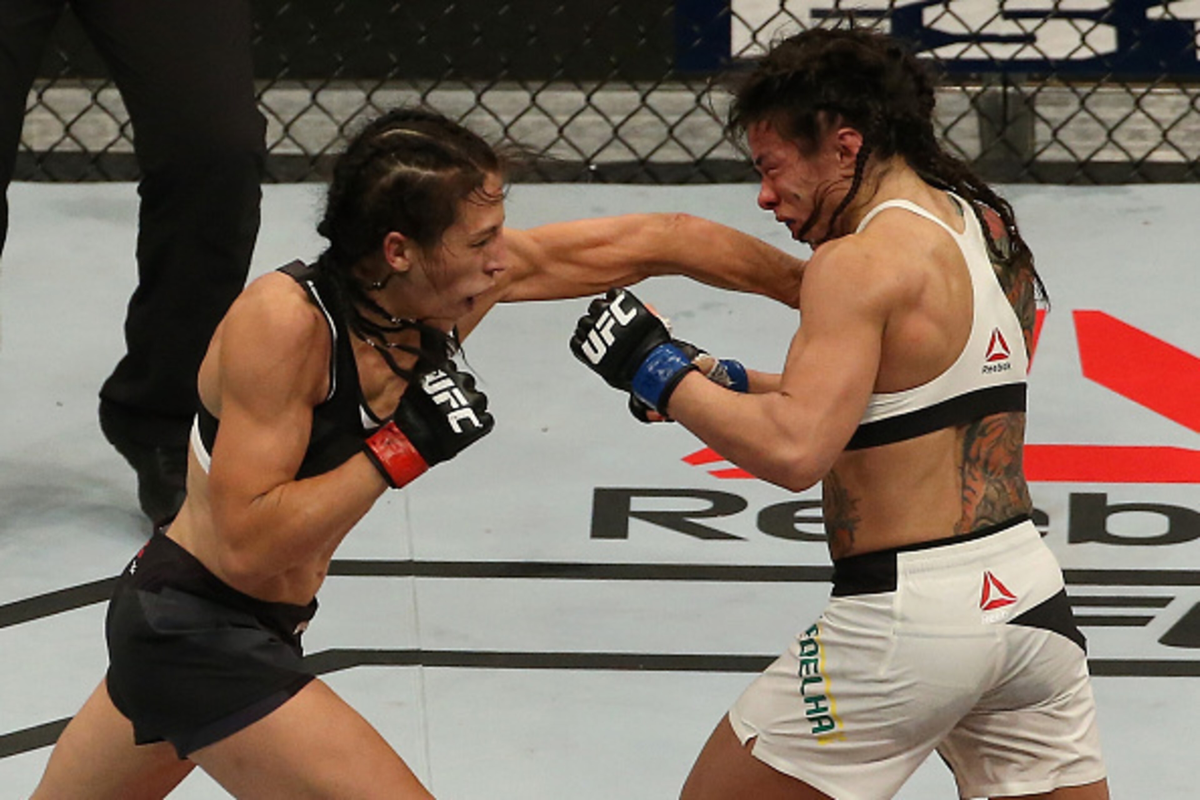 LAS VEGAS, NV - JULY 08:  (L-R) Joanna Jedrzejczyk of Poland punches Claudia Gadelha of Brazil in their UFC women's strawweight championship bout during The Ultimate Fighter Finale event at MGM Grand Garden Arena on July 8, 2016 in Las Vegas, Nevada.  (Ph