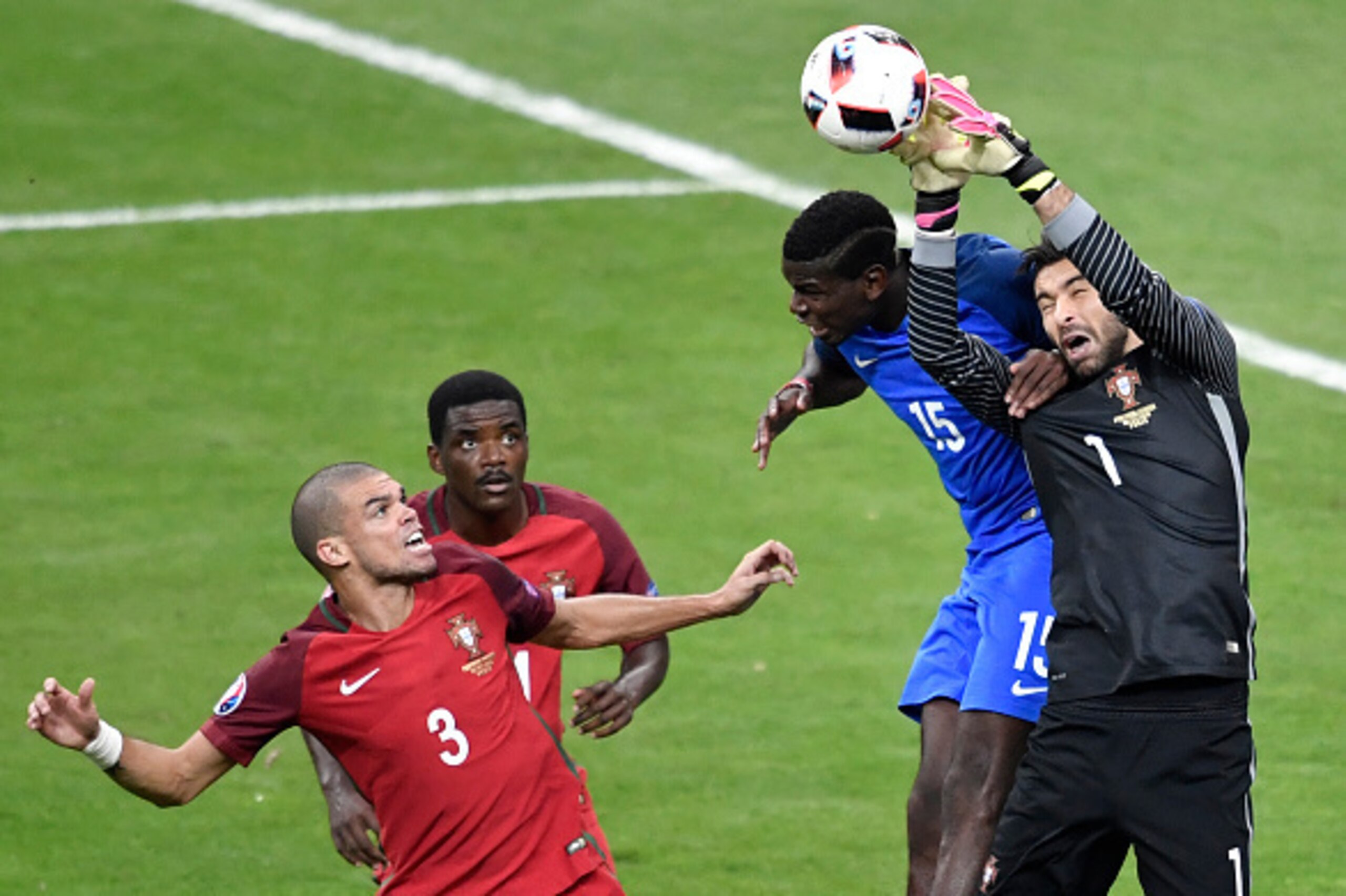 Portugal's goalkeeper Rui Patricio (R) makes a save next to (LtoR) Portugal's defender Pepe, Portugal's midfielder William Carvalho and France's midfielder Paul Pogba during the Euro 2016 final football match between Portugal and France at the Stade de Fr