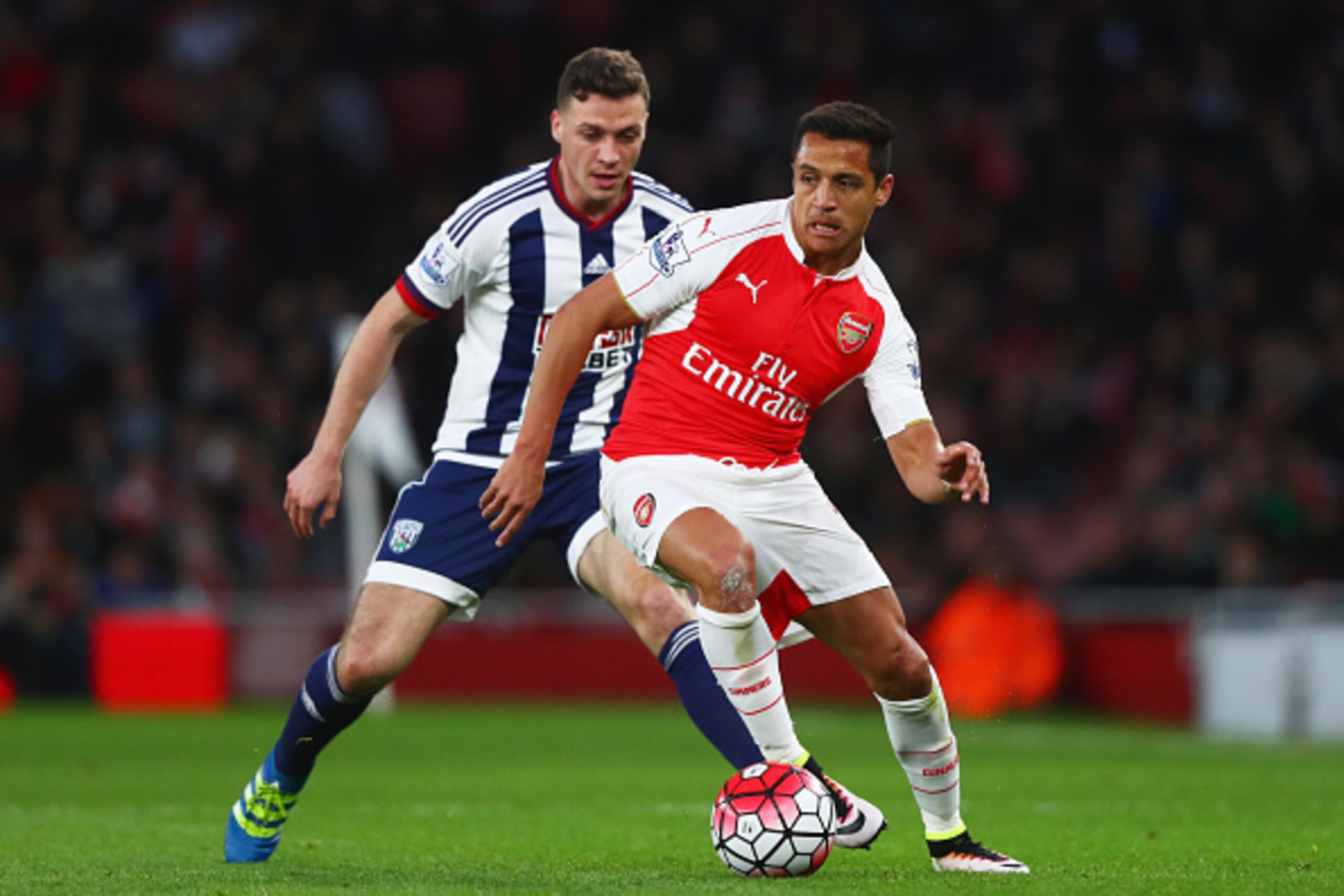 LONDON, ENGLAND - APRIL 21:  Alexis Sanchez of Arsenal is watched by James Chester of West Bromwich Albion during the Barclays Premier League match between Arsenal and West Bromwich Albion at the Emirates Stadium on April 21, 2016 in London, England.  (Ph