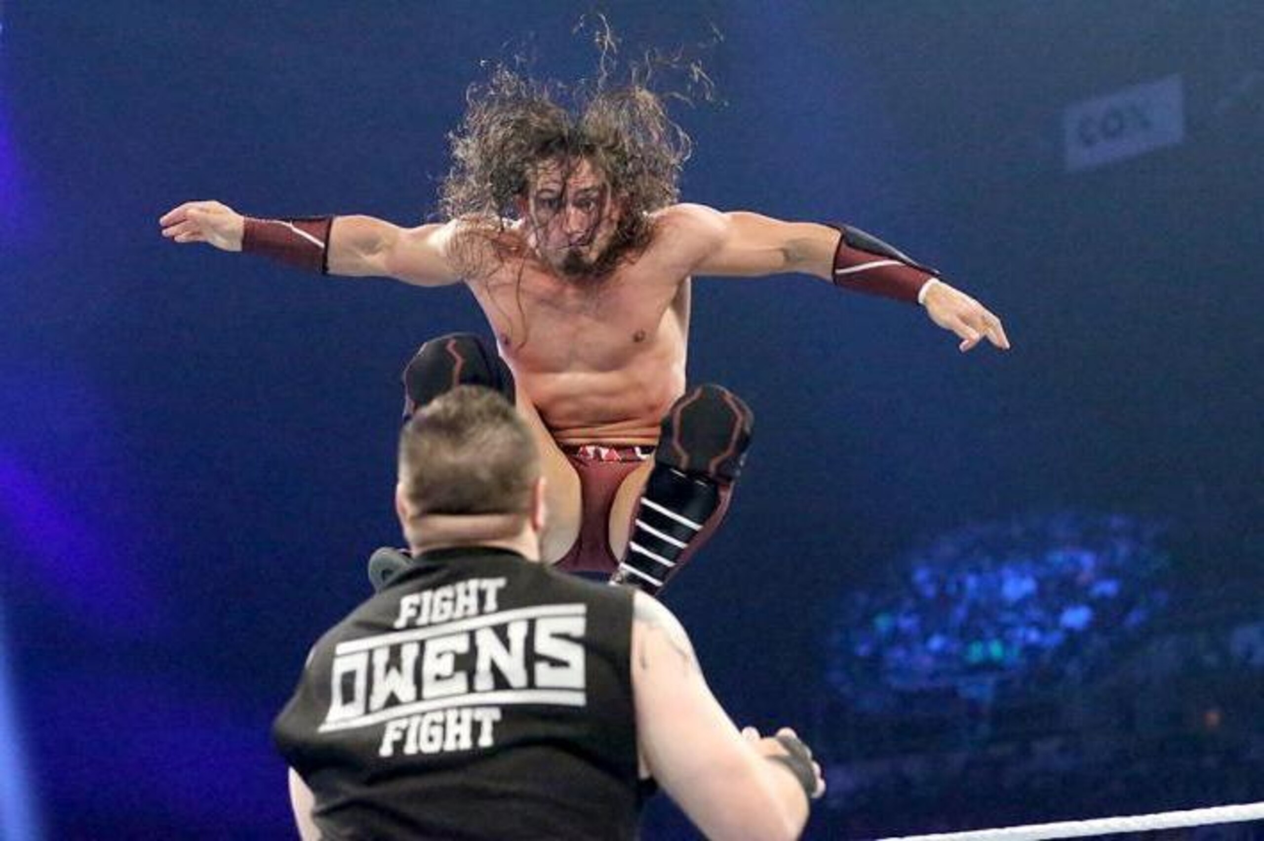 Neville leaps at Kevin Owens.