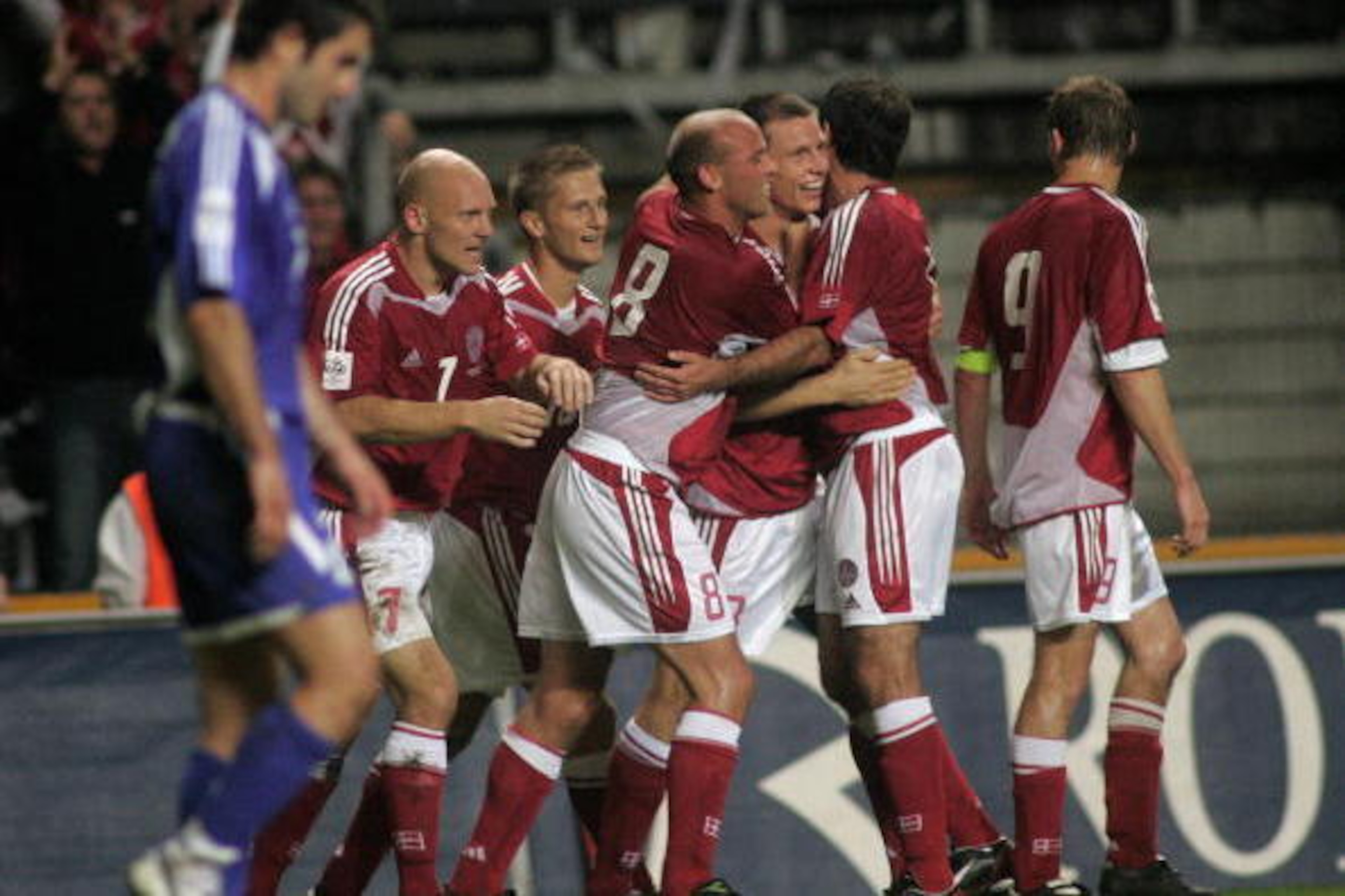 Copenhagen, DENMARK:  A Greek player passes in front of jubilating Danish players - from left: Thomas Gravesen, Martin Jorgensen, Claus Jensen, Michael Gravgaard, Niclas Jensen and Jon Dahl Tomasson - after Michael Gravgaard's goal to 1-0 during the FIFA 