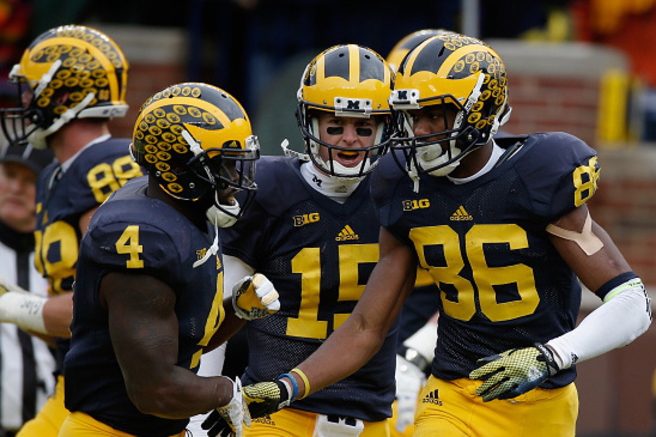 ANN ARBOR, MI - NOVEMBER 28: Jehu Chesson #86 of the Michigan Wolverines celebrates with teammates De'Veon Smith #4 and Jake Rudock #15 after catching a second quarter touchdown against the Ohio State Buckeyes at Michigan Stadium on November 28, 2015 in A