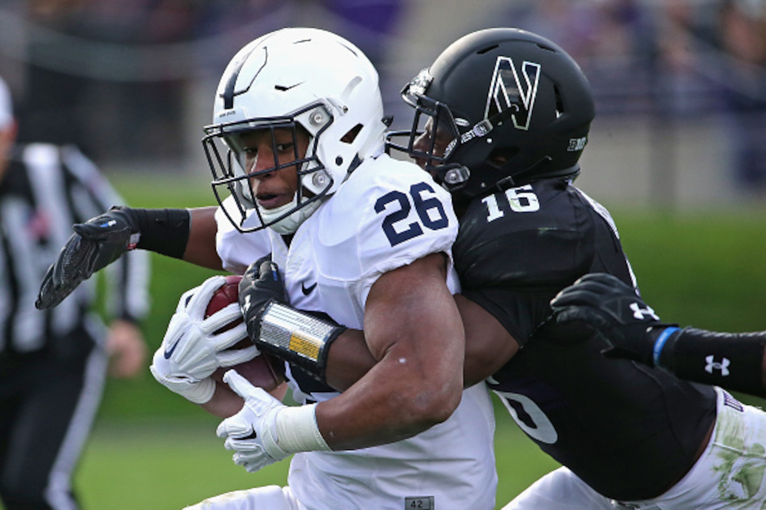 EVANSTON, IL - NOVEMBER 07: Saquon Barkley #26 is wrapped up by Godwin Igwebuike #16 of the Northwestern Wildcats at Ryan Field on November 7, 2015 in Evanston, Illinois. (Photo by JonathanDaniel/Getty Images)
