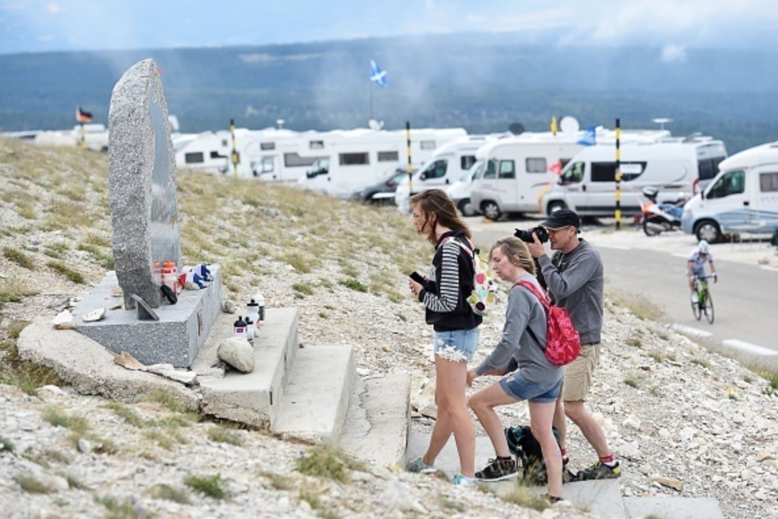 People observe late British cyclist Tom Simpson's memorial on the side of the road leading to the Mont Ventoux on July 12, 2016 two days before the passage of the Tour de France. 
Tom Simpson died of exhaustion on the slopes of Mont Ventoux during the 13t