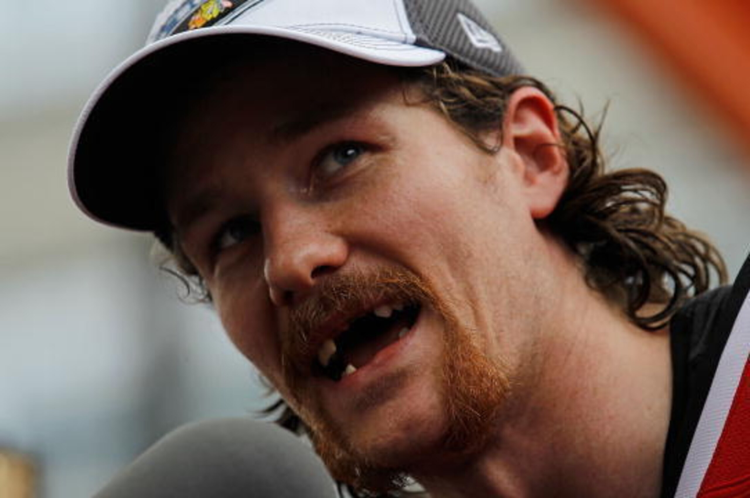 CHICAGO - JUNE 11: Duncan Keith #2, who lost seven teeth during the Stanley Cup playoffs after being hit in the mouth with a puck, speaks to the crowd during the Chicago Blackhawks Stanley Cup victory parade and rally on June 11, 2010 in Chicago, Illinois