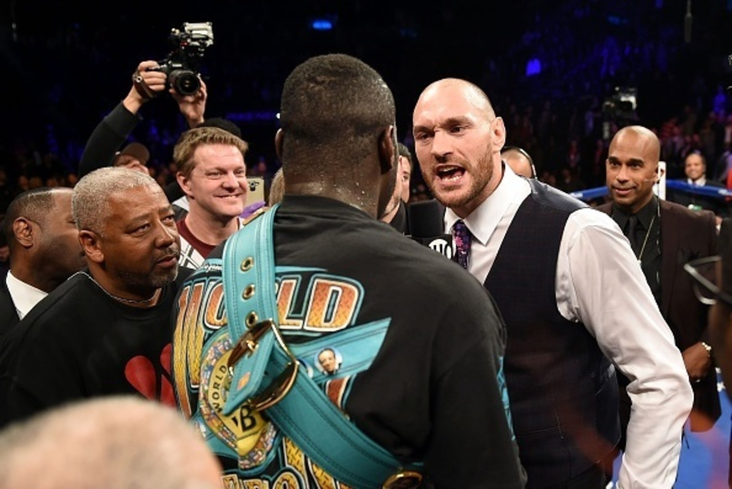 Tyson Fury of Britain (R) challeges Deontay Wilder of the US (C) after Wilder defeated Artur Szpilka of Poland in their WBC Heavyweight Championship bout at Barclay's Center in Brooklyn, New York, on January 16, 2016. 
Wilder knocked out Szpilka in the ni