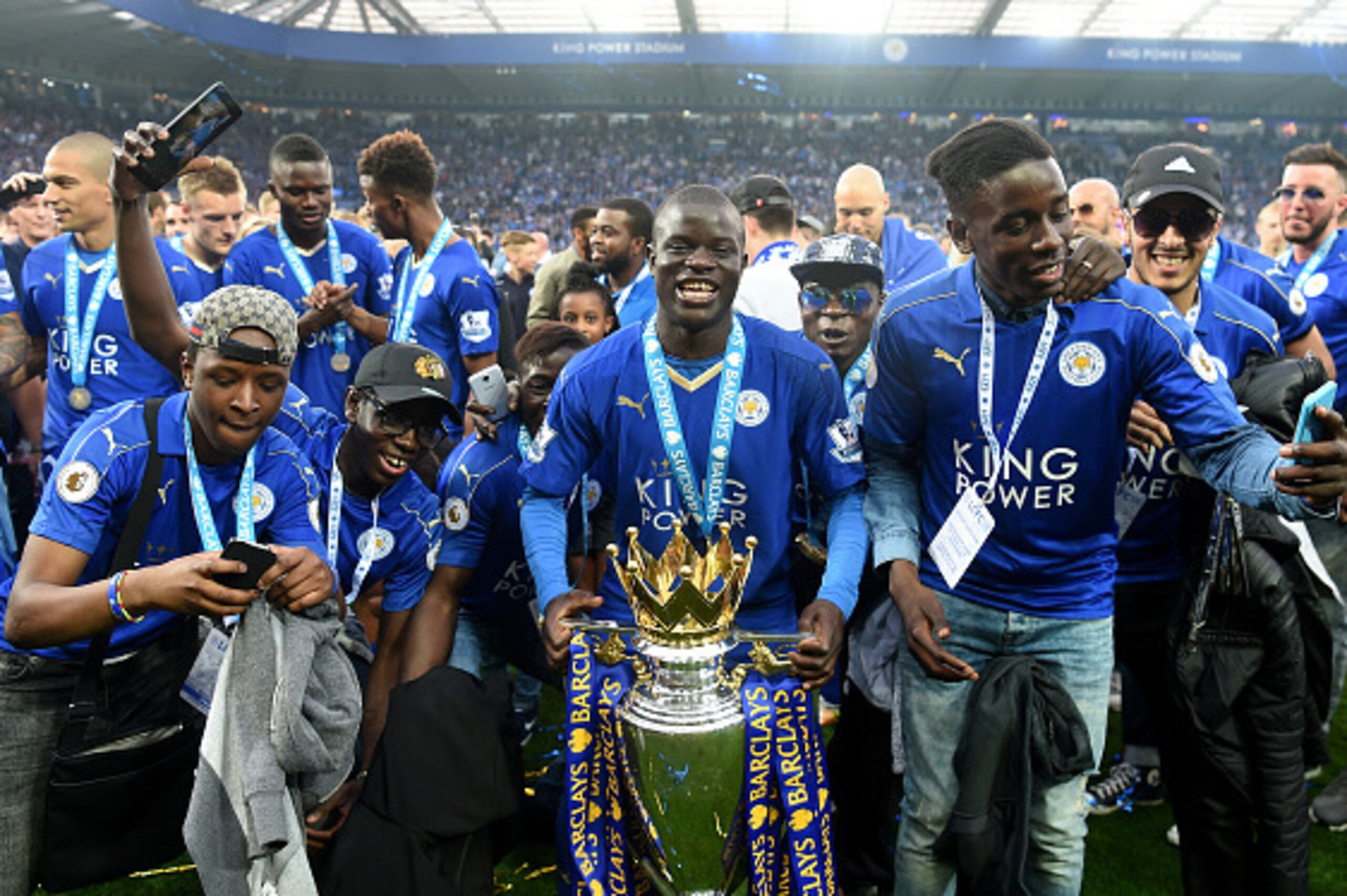 LEICESTER, ENGLAND - MAY 07: Ngolo Kante of Leicester City poses with the Premier League Trophy with his family as players and staffs celebrate the season champion after the Barclays Premier League match between Leicester City and Everton at The King Pow LEICESTER, ENGLAND - MAY 07: Ngolo Kante of Leicester City poses with the Premier League Trophy with his family as players and staffs celebrate the season champion after the Barclays Premier League match between Leicester City and Everton at The King Pow